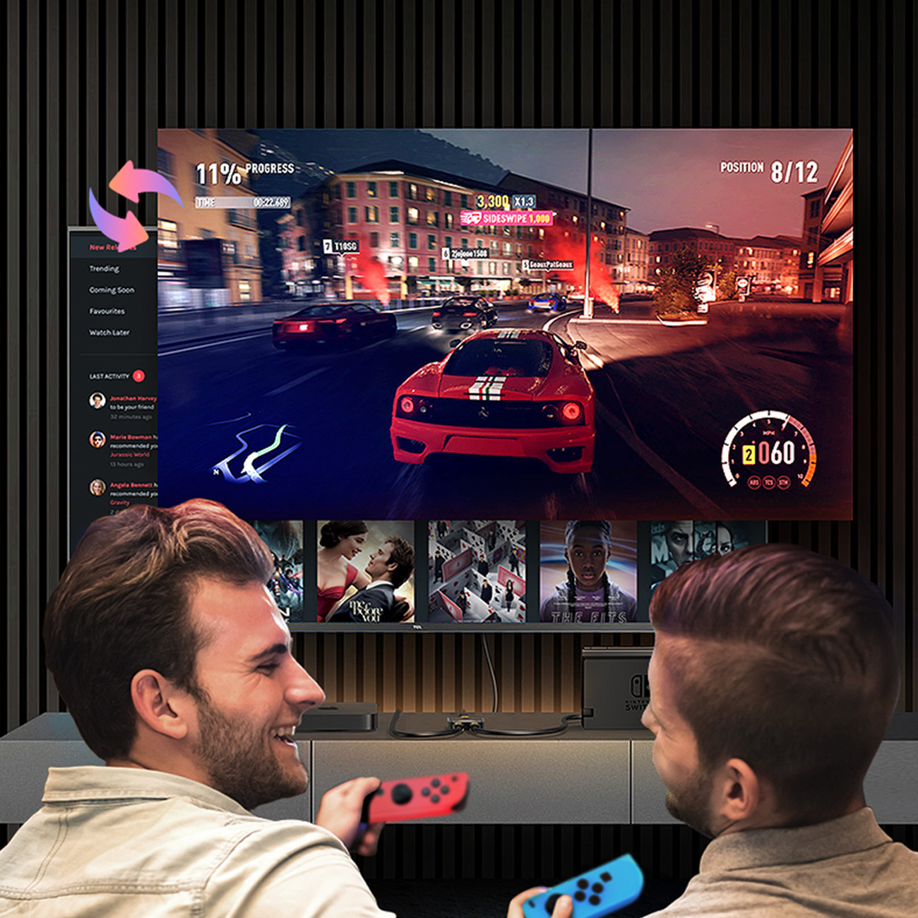 Dwóch mężczyzn gra w gry wideo z kontrolerami. Ekran pokazuje grę wyścigową z czerwonym samochodem. Inne filmy są na ekranie.
