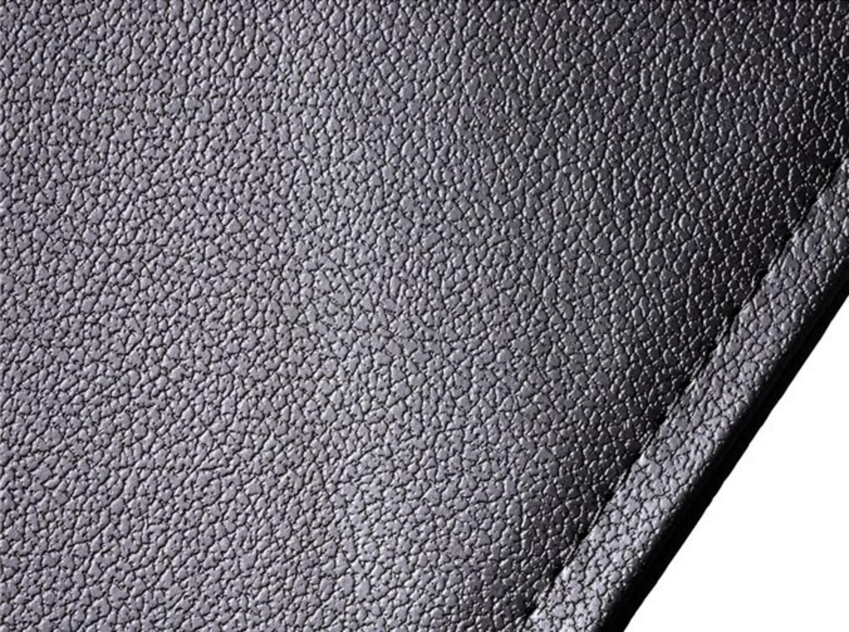 Zbliżenie czarnej tekstury skóry. Powierzchnia jest szorstka i nierówna, z małymi wypukłościami.