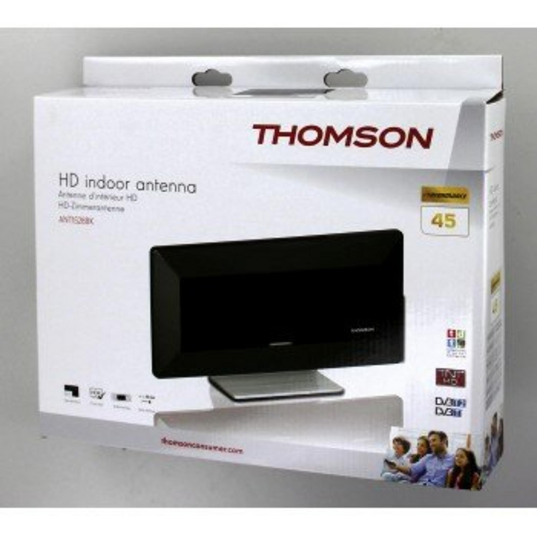Wyświetlane jest białe pudełko z czarną anteną. Na pudełku znajduje się marka THOMSON. Tekst brzmi 'HD indoor antenna'.