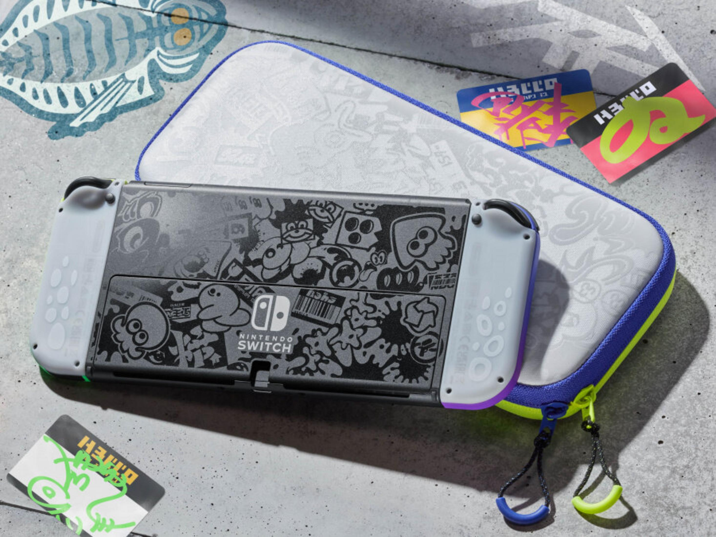 Consola Nintendo Switch con funda y tarjetas de juego, con diseños de Splatoon. Predominan los colores gris, azul y amarillo.