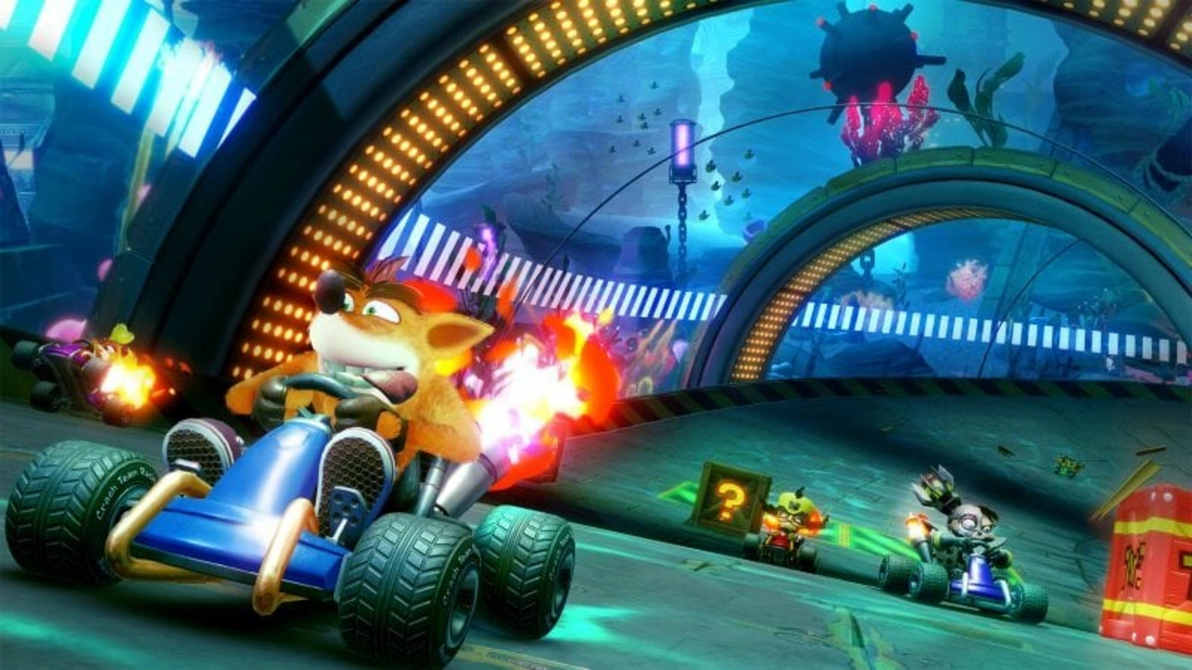 Wyścigi gokartów Crash Bandicoot. Crash w niebieskim gokarcie z ogniem. Widoczni inni zawodnicy i podwodne tło.
