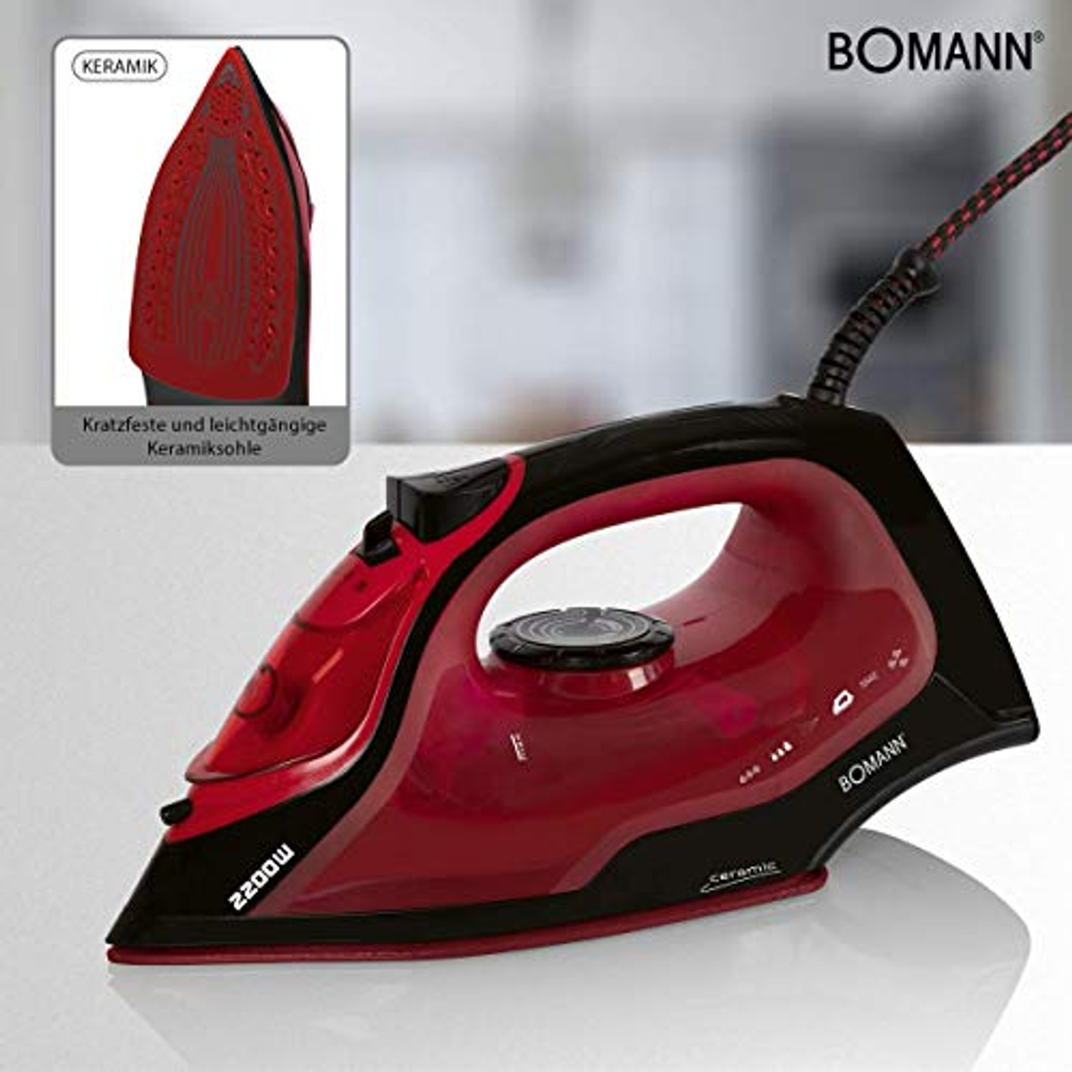 Czerwono-czarne żelazko Bomann. Posiada ceramiczną stopę i moc 2200 W. Mała wstawka pokazuje szczegóły stopy żelazka.