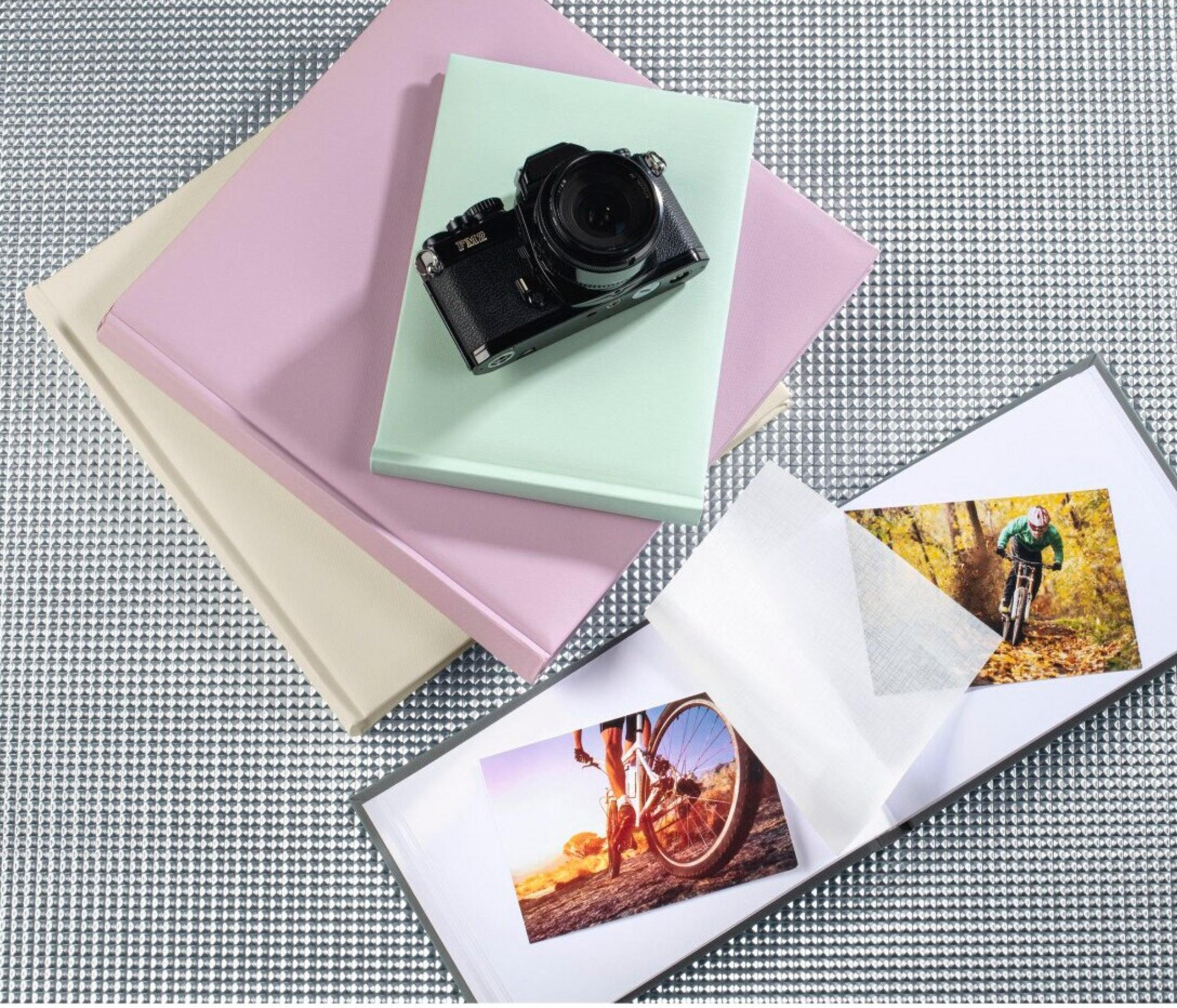 Widok z góry przedstawia aparat na książkach. Jedna z książek ukazuje rowerzystę. Tło jest teksturowane.