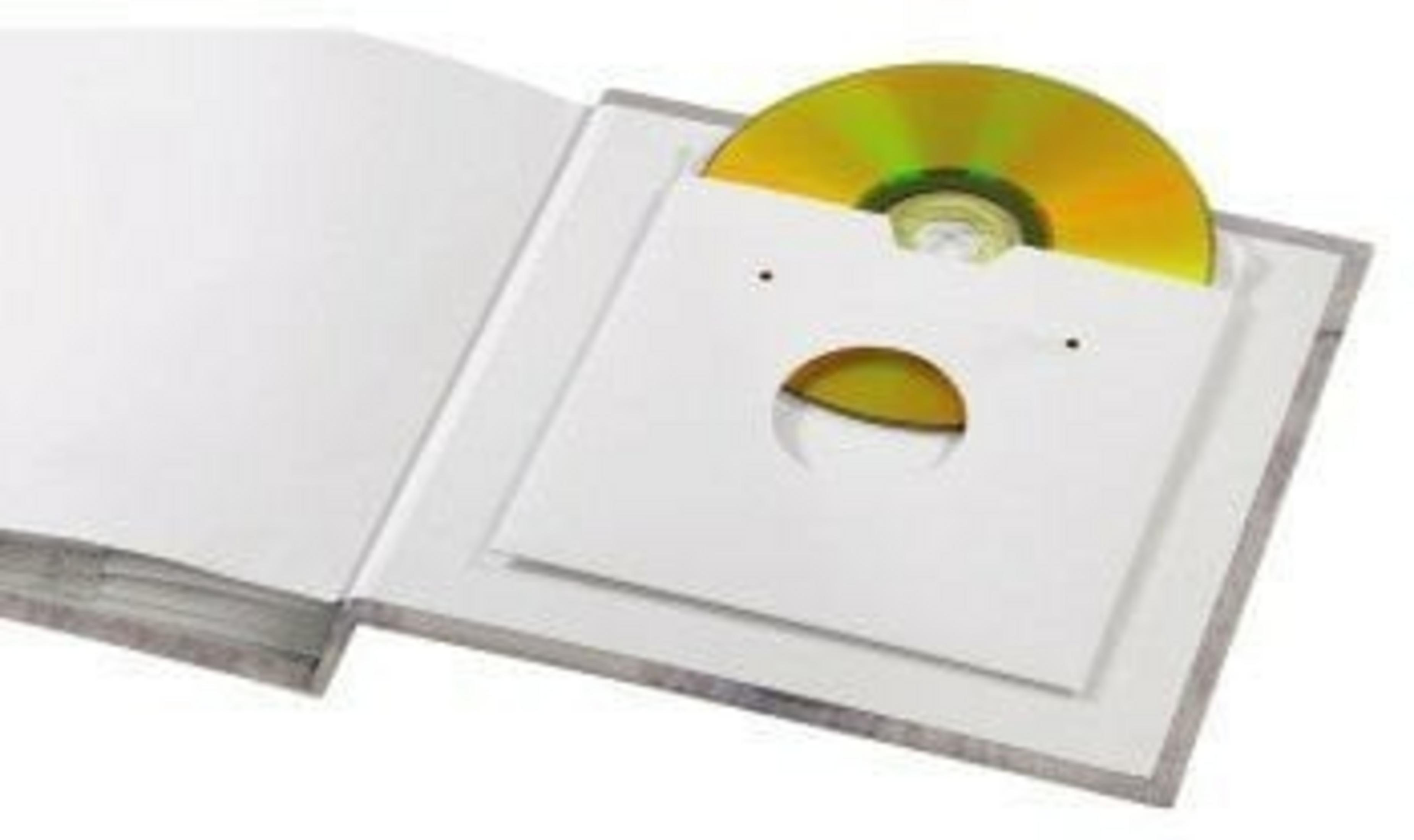 Un CD está en su estuche de papel blanco, dentro de un libro abierto. El CD es parcialmente visible. El libro está abierto sobre una mesa.