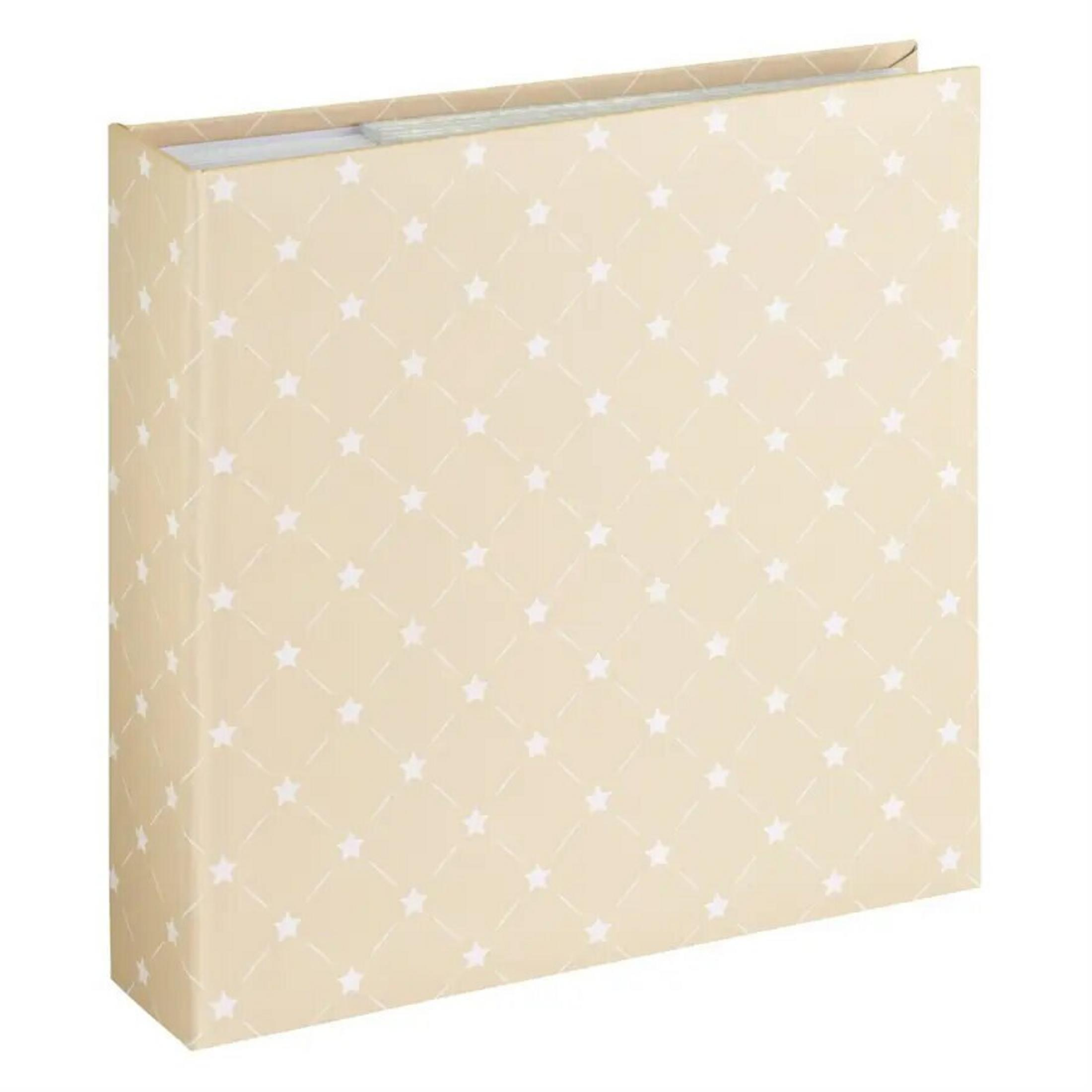 Beżowy album na zdjęcia ze wzorem gwiazd. Okładka ma białe gwiazdy i linie. Album stoi pionowo.