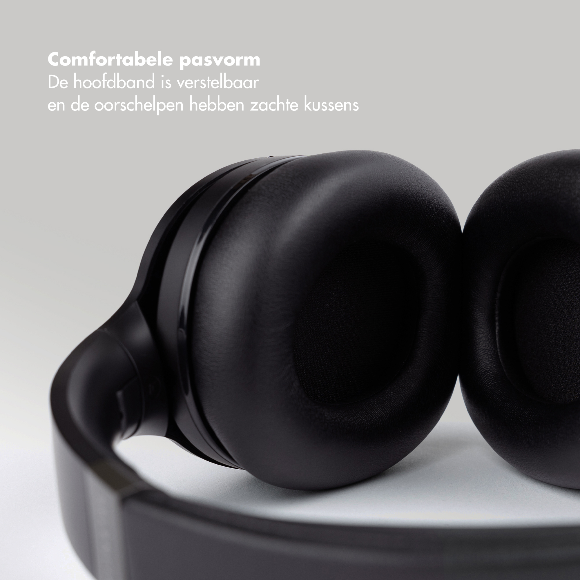 Close-up van zwarte koptelefoon. Hoofdband en oorschelpen zijn zichtbaar. Nederlandse tekst: 'Comfortabele pasvorm'.