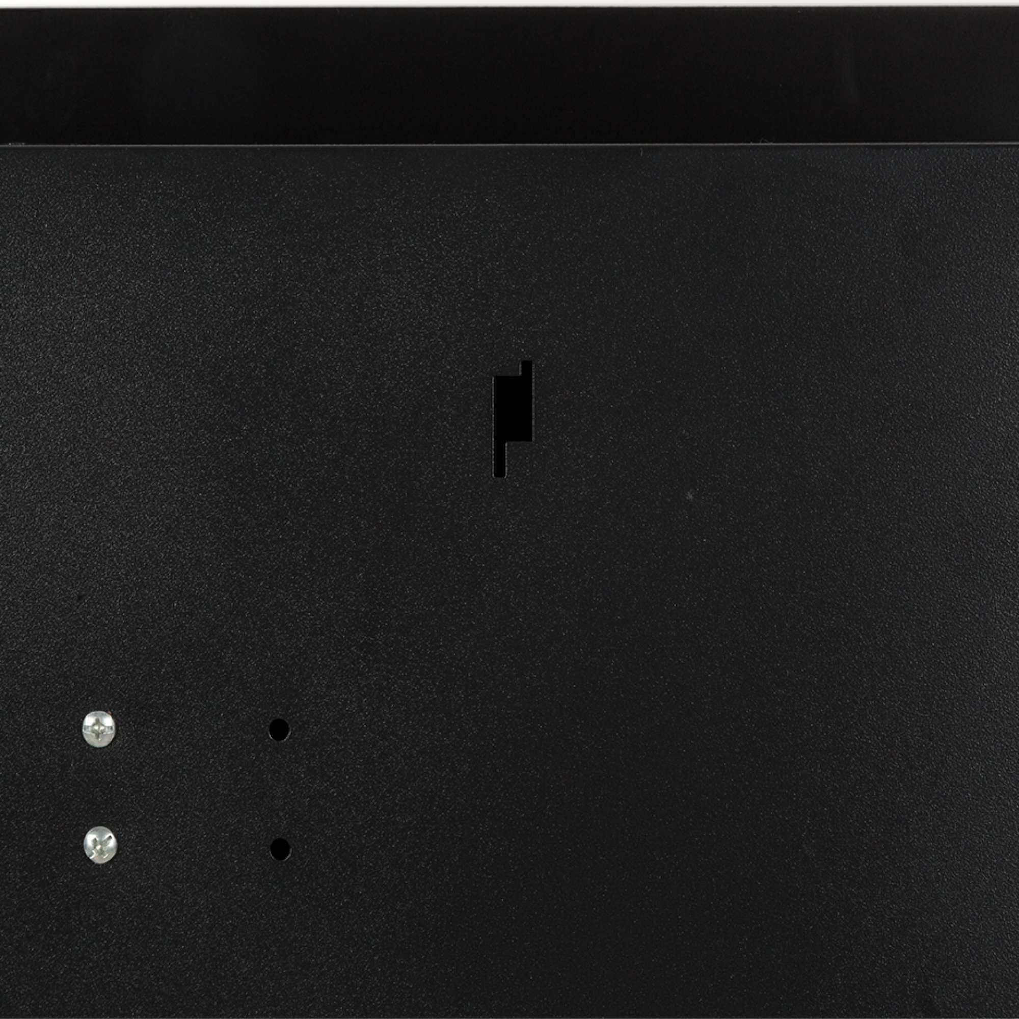 Primer plano de un panel negro. El panel tiene una superficie texturizada con tornillos y agujeros. Hay un recorte.