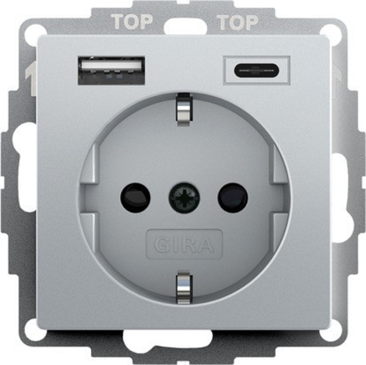 Una presa a muro grigia con porte USB e USB-C. Ha una presa rotonda con tre fori e una vite centrale, con il marchio GIRA.