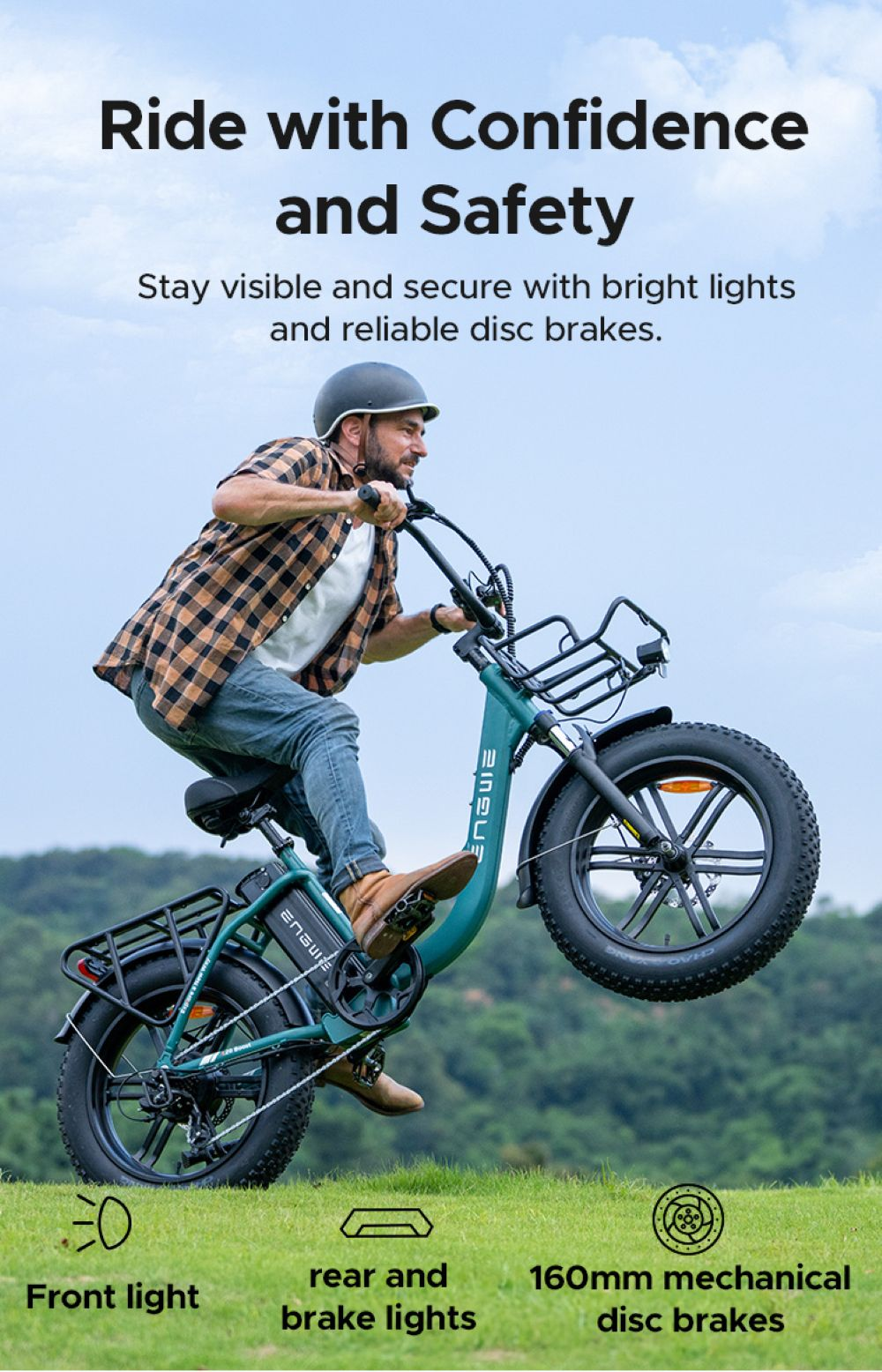 Un hombre monta en una bicicleta eléctrica, levantando la rueda delantera. La bicicleta es de color turquesa, con una baca negra. El fondo es un campo de hierba con cielo azul.