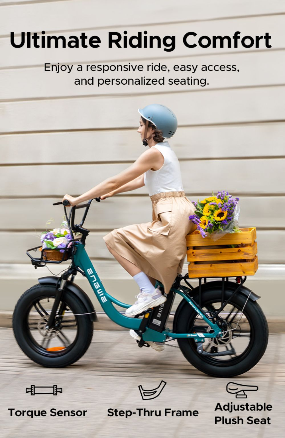 Una mujer monta una bicicleta verde azulado con flores. Tiene una caja de madera, neumáticos negros y el texto "ENGUIE".
