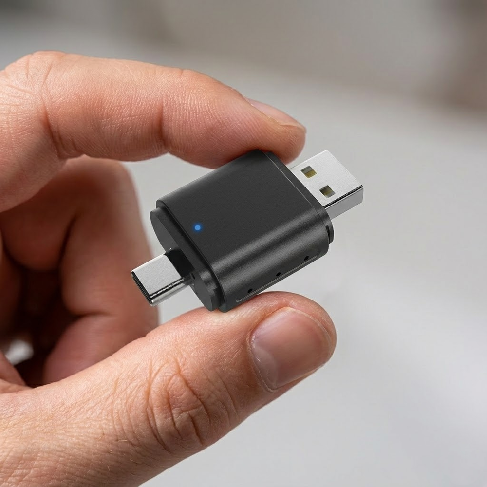 Bir el, Type-C ve USB konnektörlü siyah bir USB adaptörünü tutuyor. Adaptörde mavi bir ışık yanıyor.
