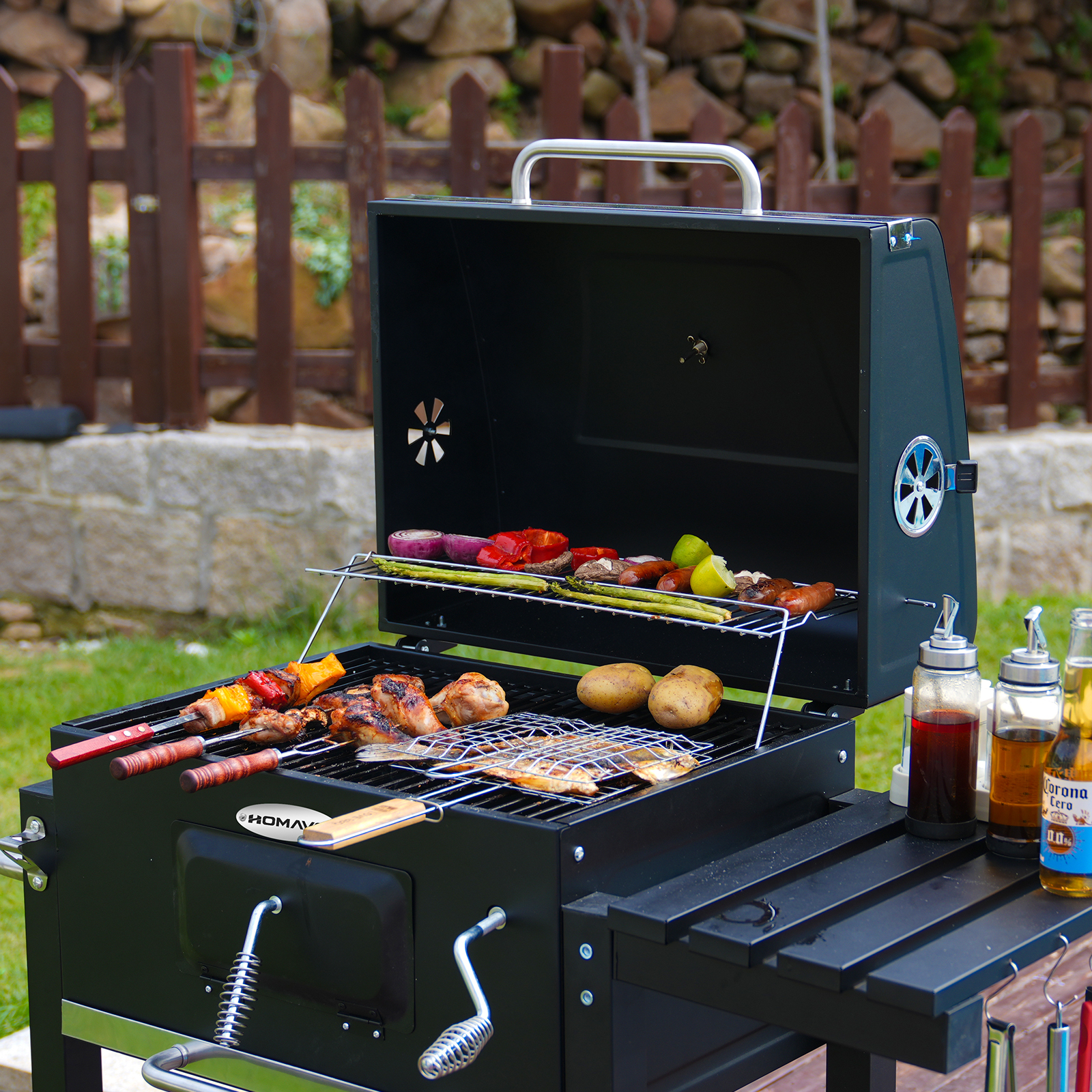 Grill z różnymi grillowanymi potrawami. Zawiera warzywa, mięso i ryby. Butelki oleju i piwa obok.