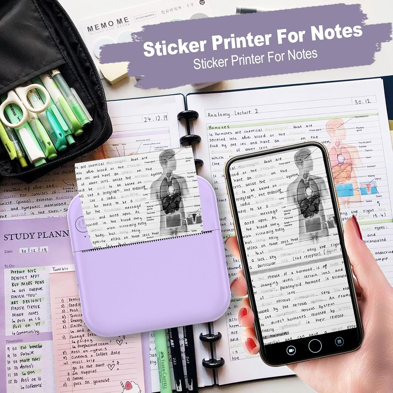 Ein Schreibtisch mit Drucker, Notizen, Stiften und einem Telefon mit anatomischer Zeichnung.