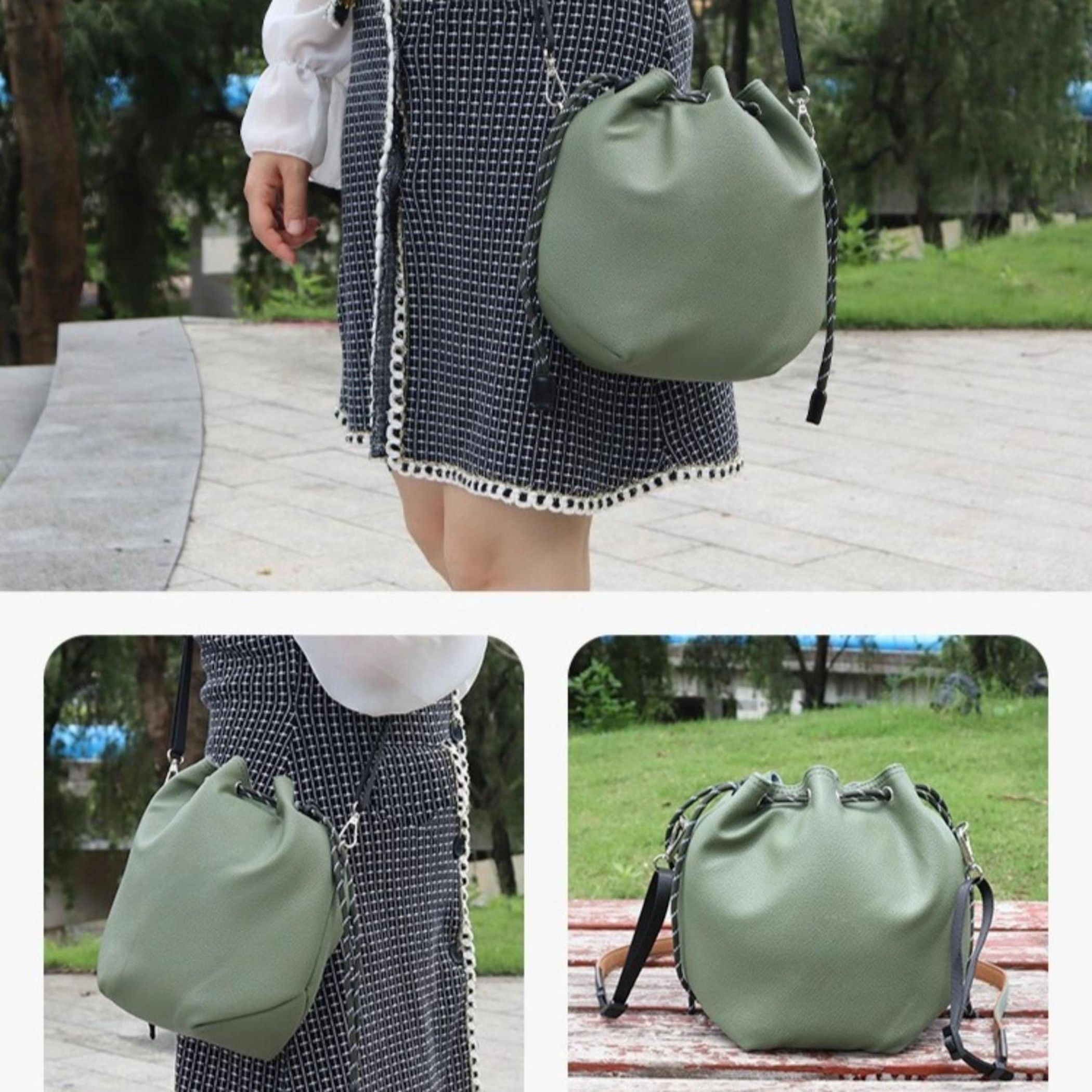 Eine Frau in einem schwarz-weißen Kleid mit einer grünen Eimertasche. Der Hintergrund zeigt Bäume und einen Gehweg.