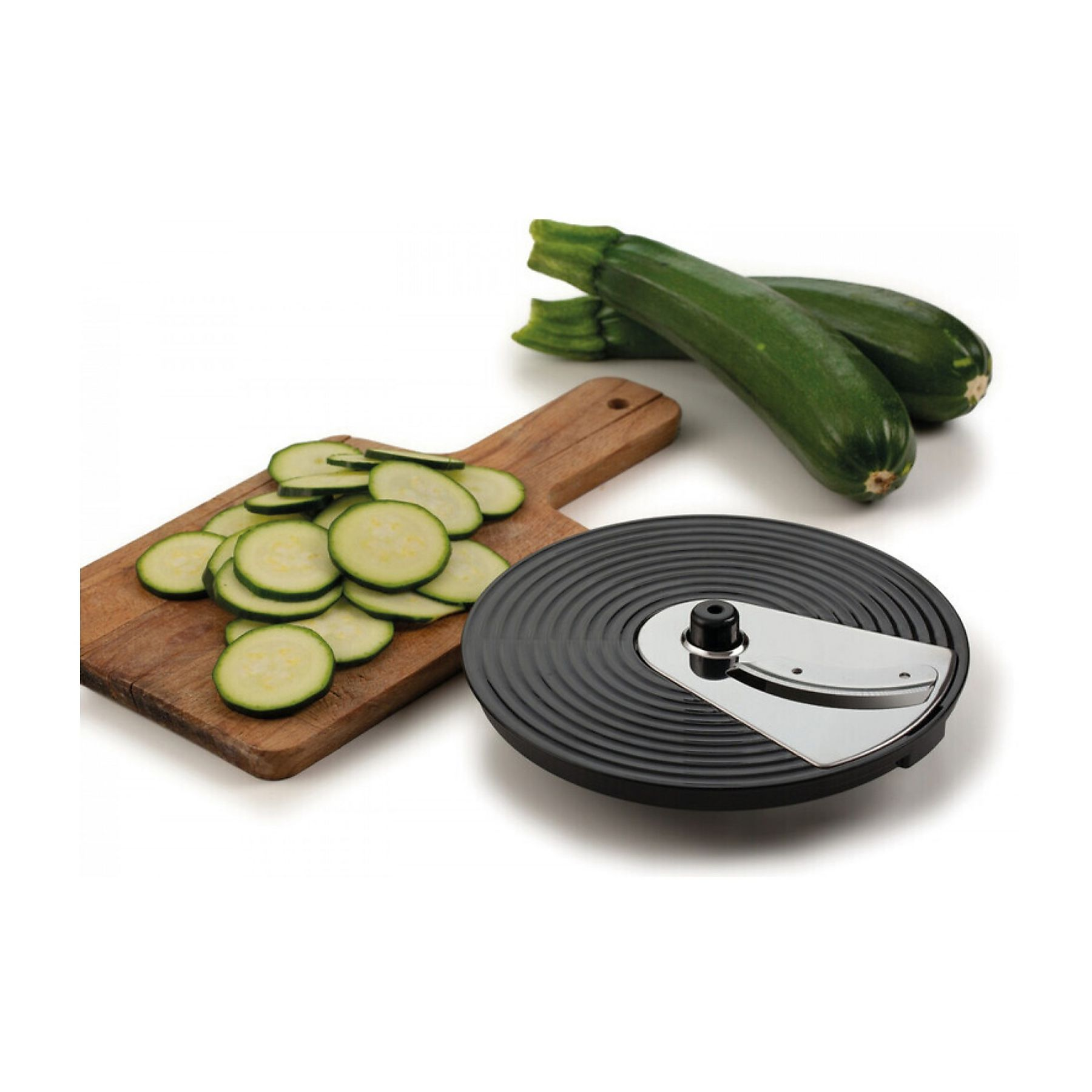 L'immagine mostra zucchine a fette su un tagliere di legno, con zucchine intere e un affettatrice su sfondo bianco.