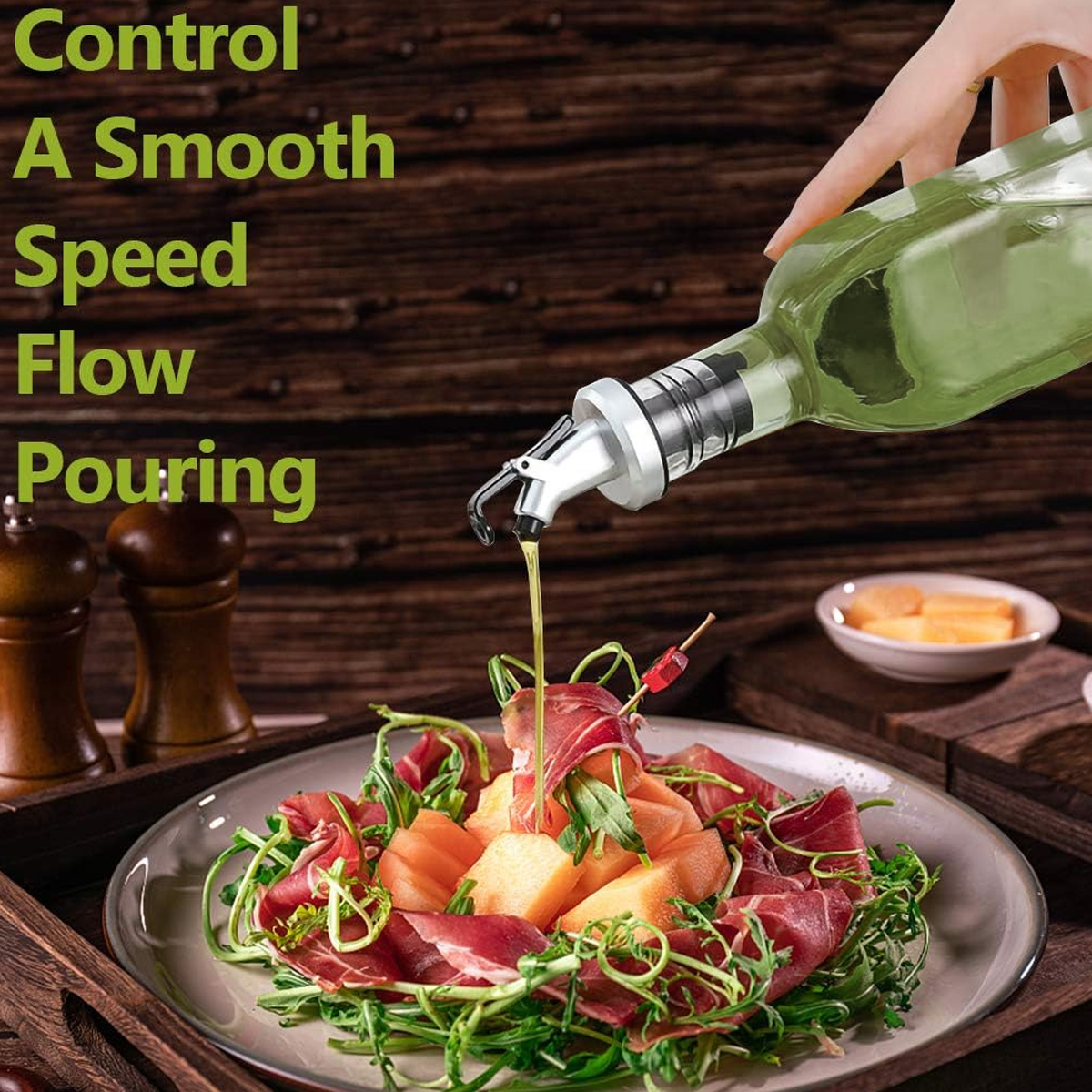 Eine Olivenölflasche gießt Öl auf einen Teller Salat mit Melone und Schinken. Holz Hintergrund.