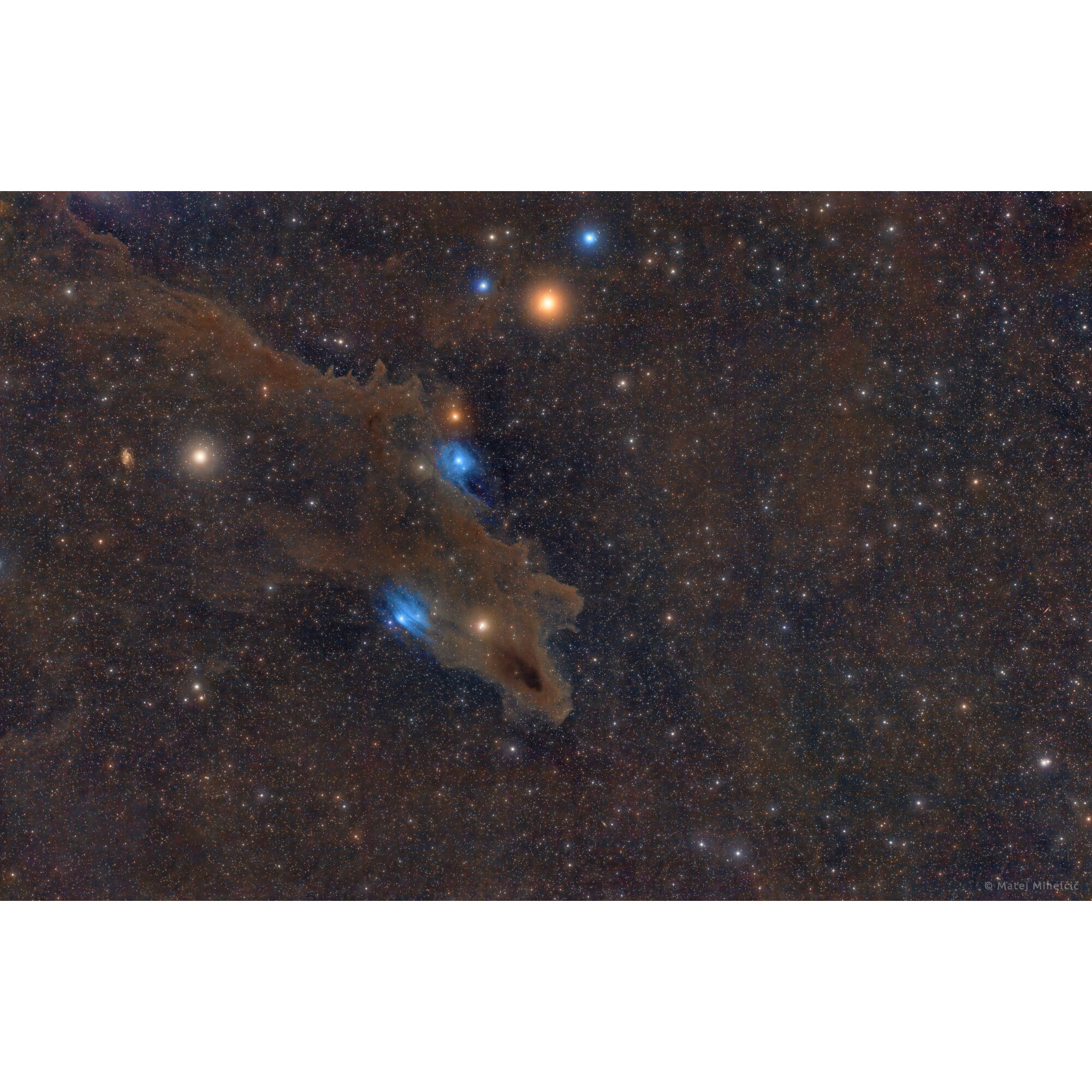 Nebel mit blauen Sternen und braunem Staub vor dem Hintergrund unzähliger Sterne im Weltraum.