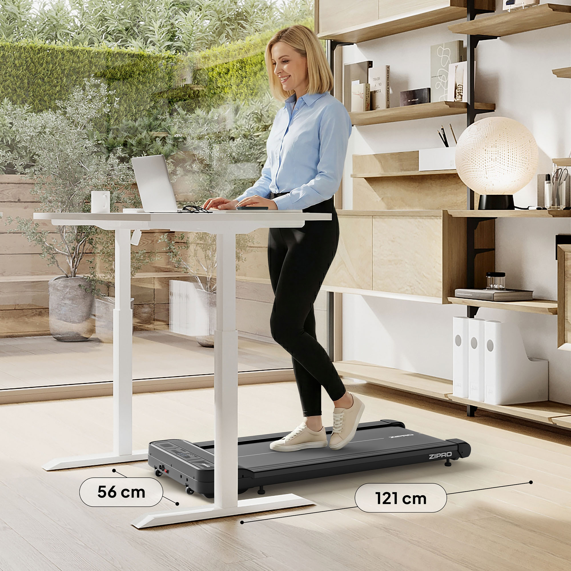 Frau geht auf einem Laufband an einem Stehpult. Laptop auf dem Schreibtisch, Regale im Hintergrund und Blick ins Freie.