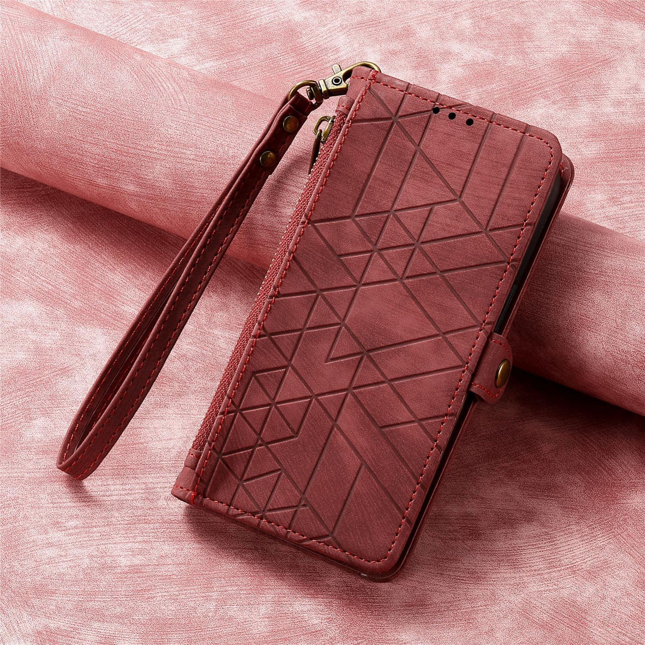 Eine weinrote Handyhülle mit geometrischem Muster, Handschlaufe und einem strukturierten, rosa Hintergrund.