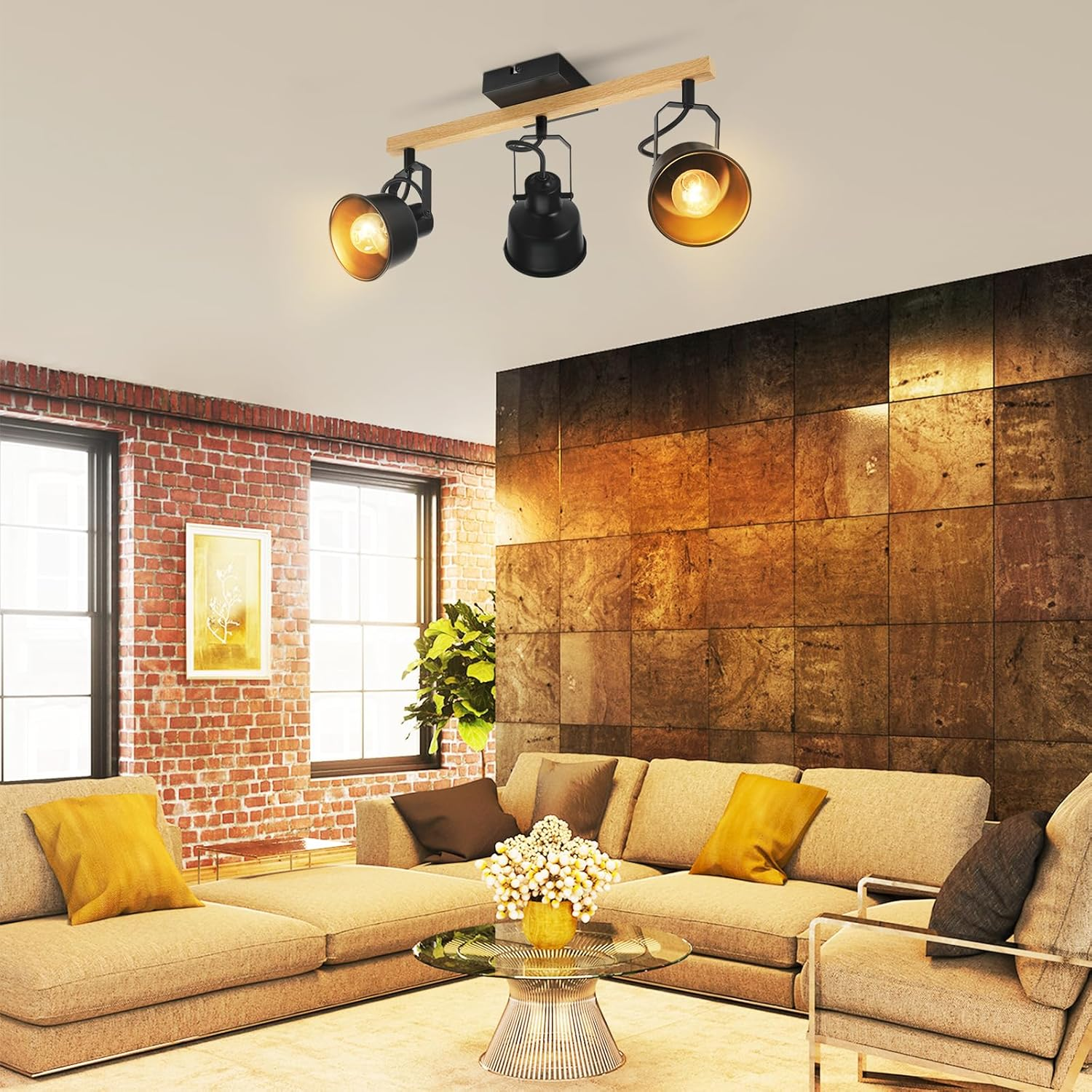 Salon z drewnianą belką z trzema reflektorami. Sofa, krzesła, szklany stół i ceglana ściana.