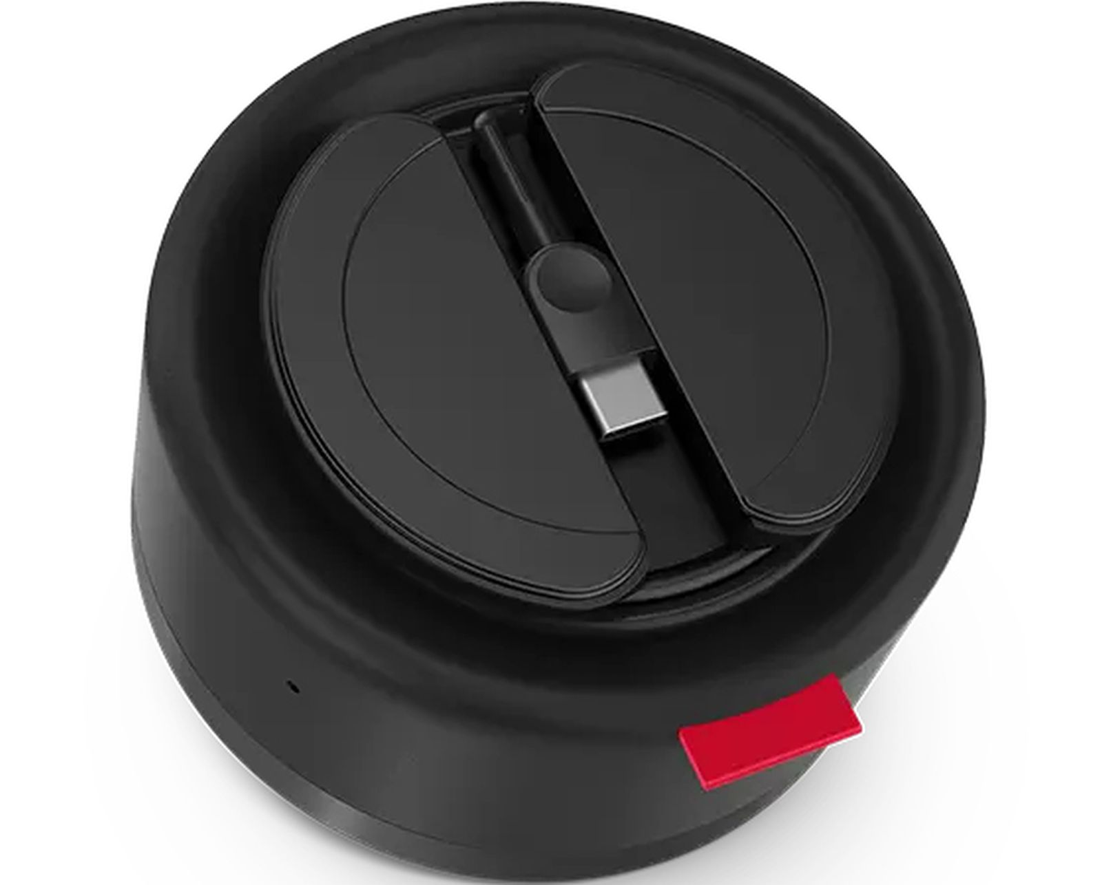 Dispositivo circolare nero con parte superiore nera con porta USB-C e linguetta rossa sul lato. Lo sfondo è bianco.