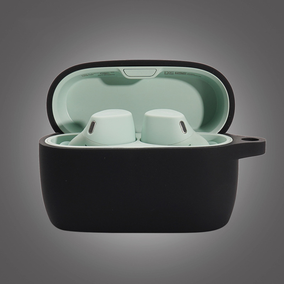 Otwarta czarna obudowa z miętowym wnętrzem, mieszcząca dwie miętowe słuchawki. Obudowa jest otwarta, na szarym tle.
