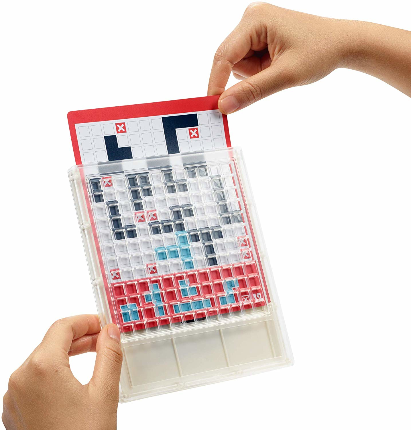 Mani che tengono un gioco trasparente. Viene inserita una carta rossa, che mostra forme nere e X rosse. Il tabellone è pieno di quadrati colorati.