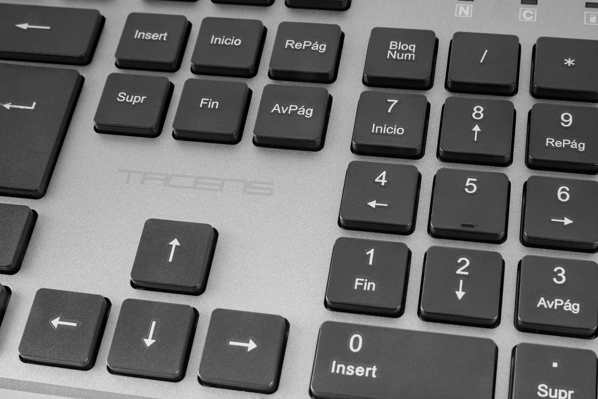 Primo piano di una tastiera di computer. Tasti neri con etichette bianche su superficie argentata. Numeri e simboli visibili.