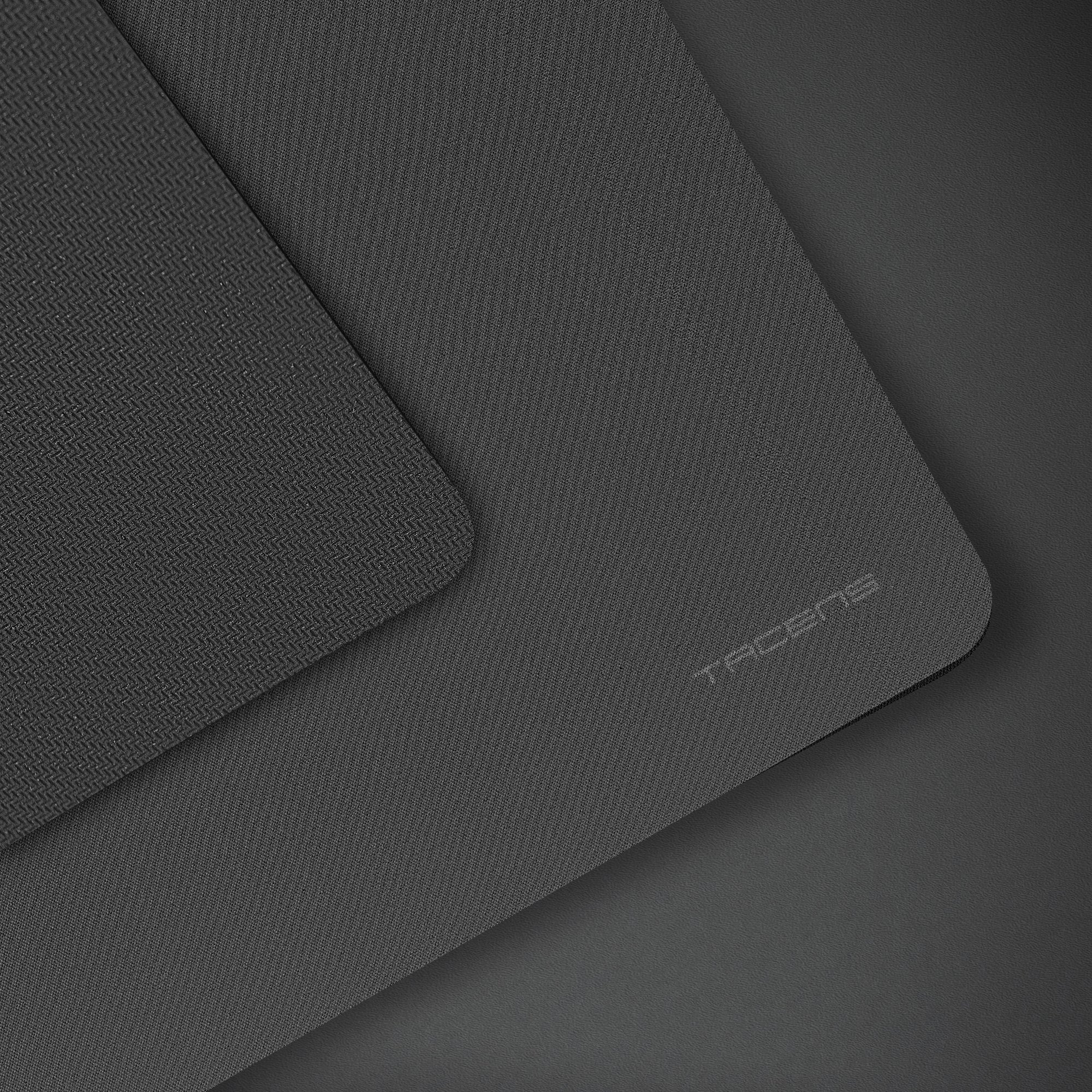 Mousepad grigio scuro con superfici strutturate. La parola TRACENS è visibile.