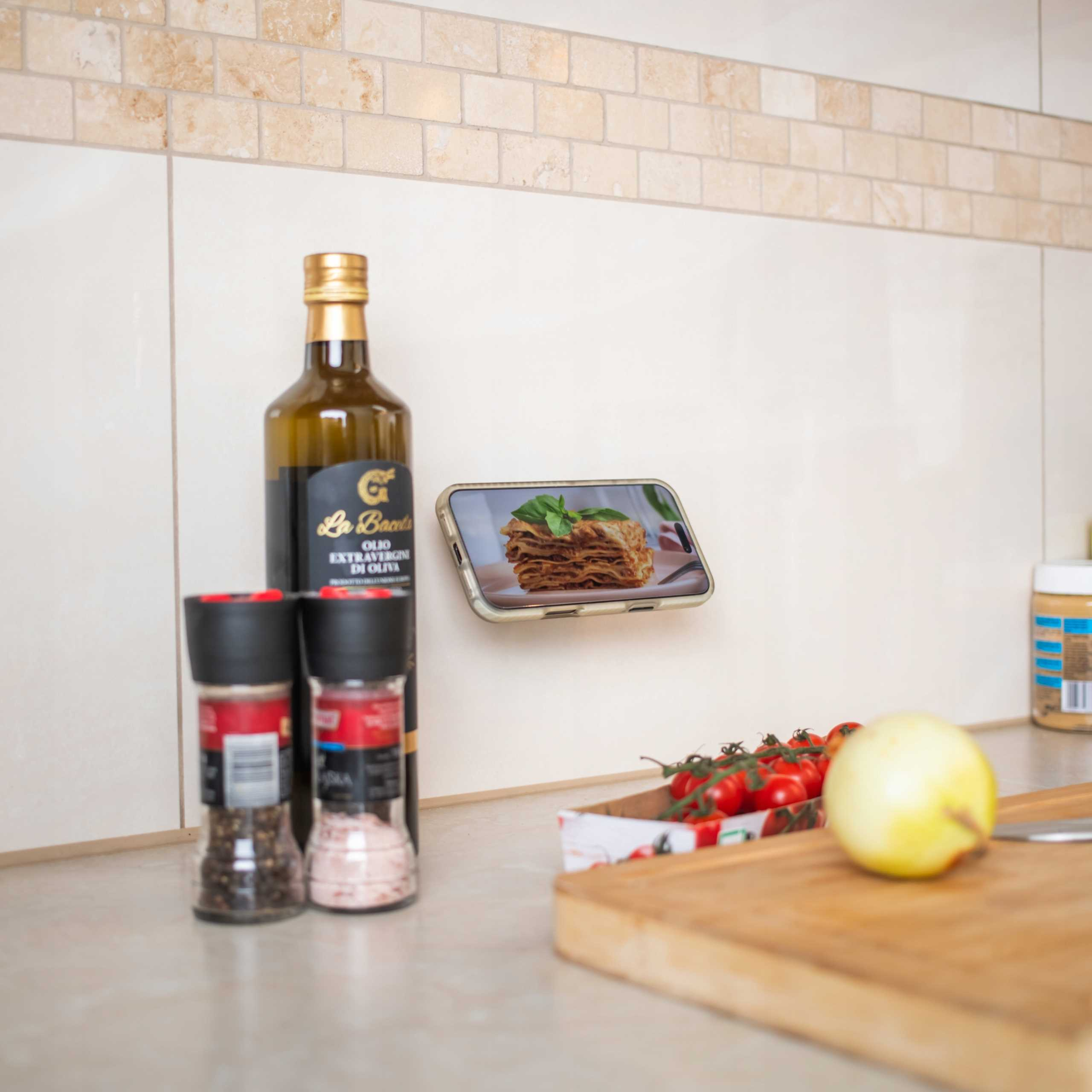 Scena kuchenna z oliwą z oliwek, solą, pieprzem, pomidorami, cebulą i telefonem z lasagne.