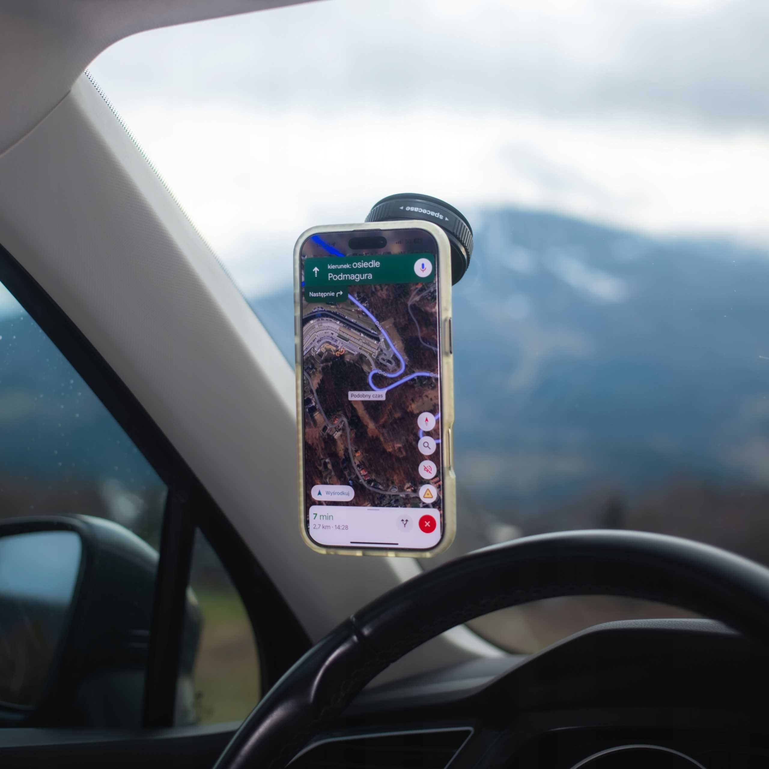 Telefon z nawigacją zamontowany w samochodzie. Ekran pokazuje mapę z celem Podmagura.