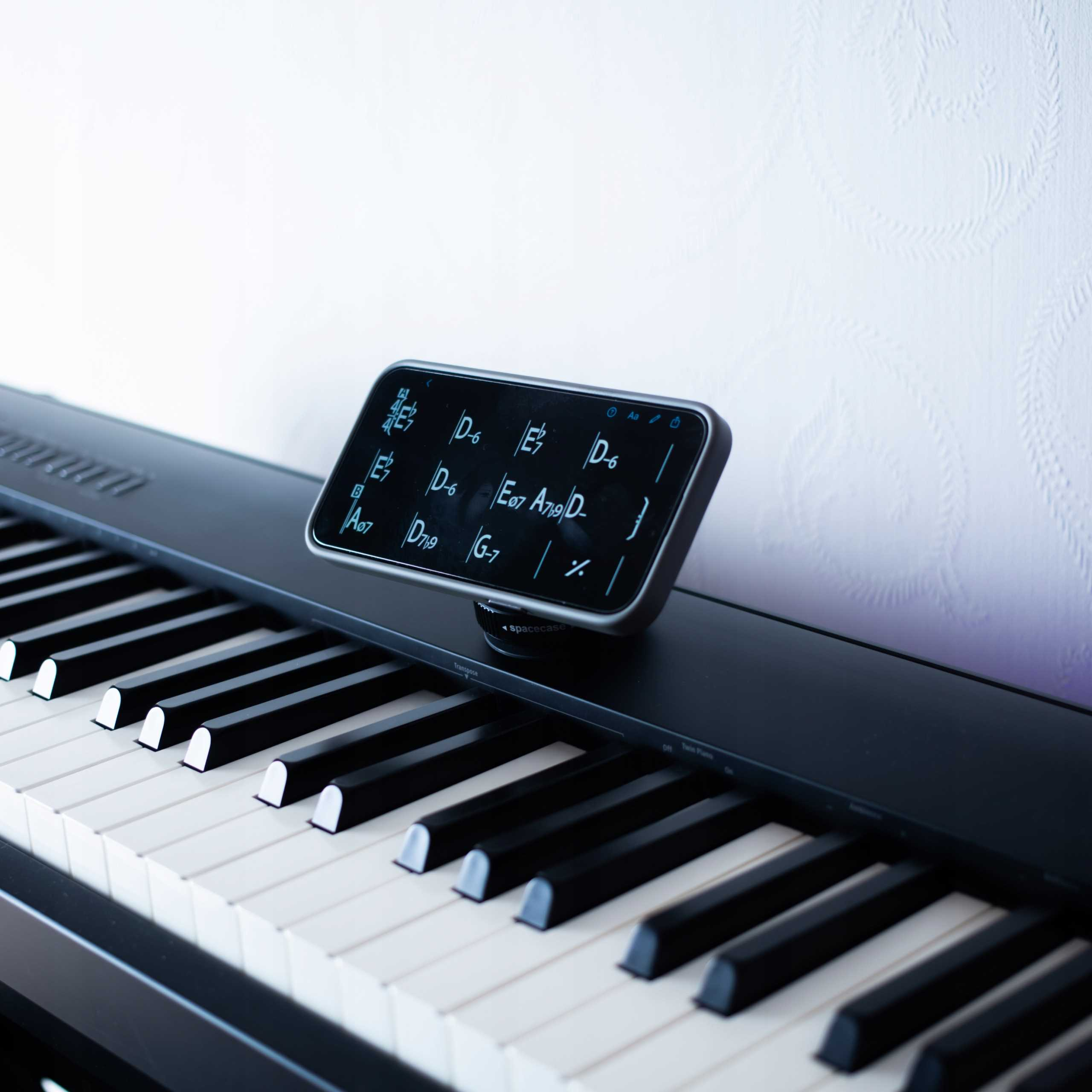 Klawiatura fortepianu z ekranem wyświetlającym nuty. Klawisze są czarno-białe. Tło jest białe.