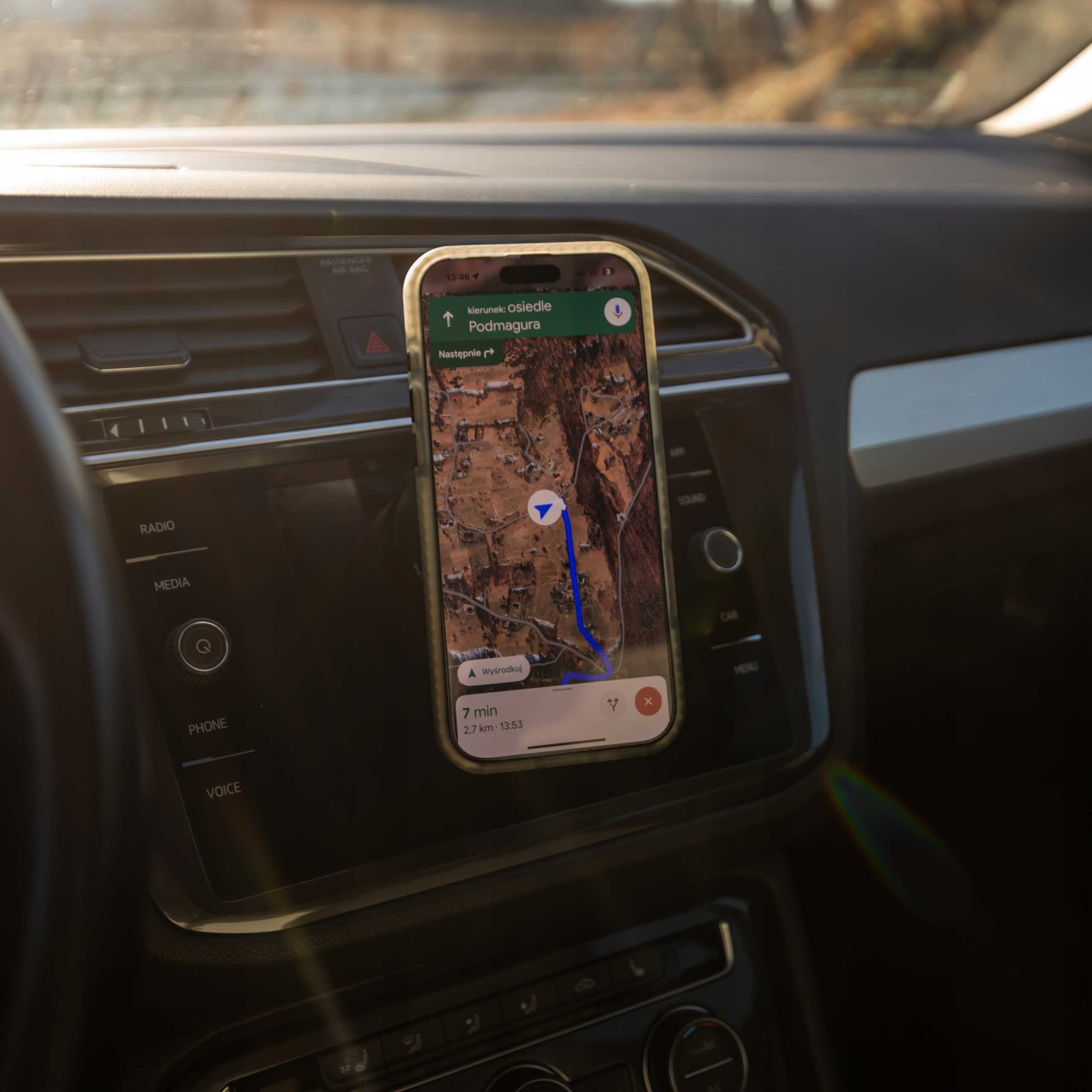 Telefon z mapą zamontowany w samochodzie. Mapa pokazuje trasę do Osiedle Podmagura.