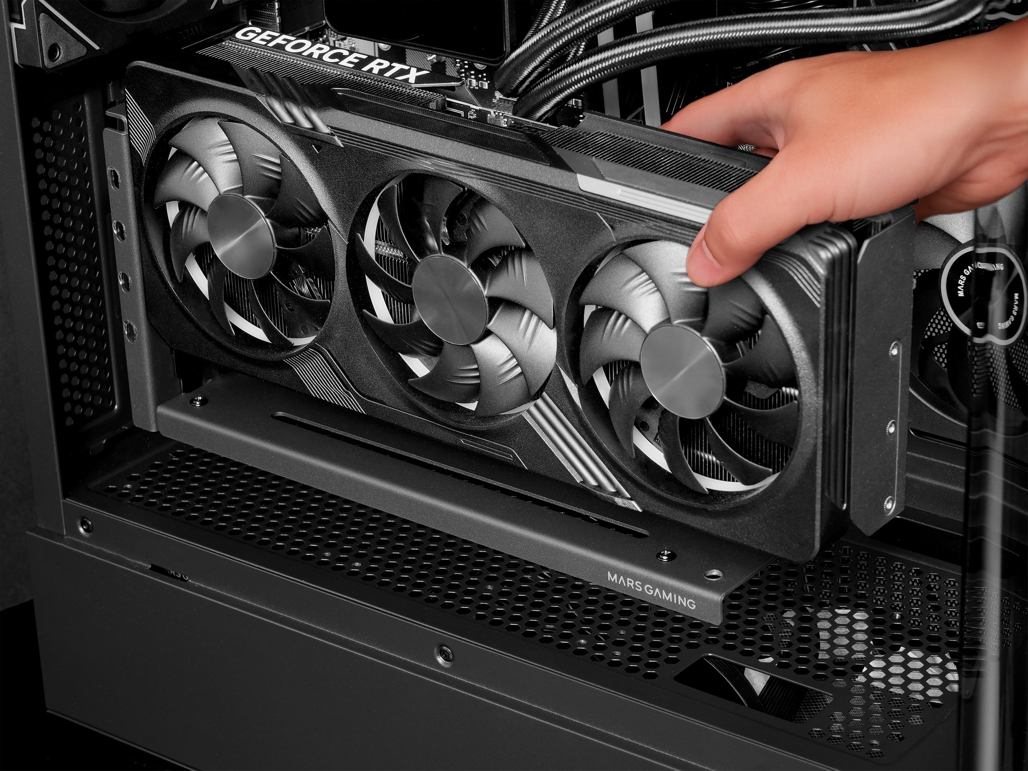 Mano che installa una scheda grafica GeForce RTX nera con tre ventole in un case per computer. Il case è anch'esso nero.