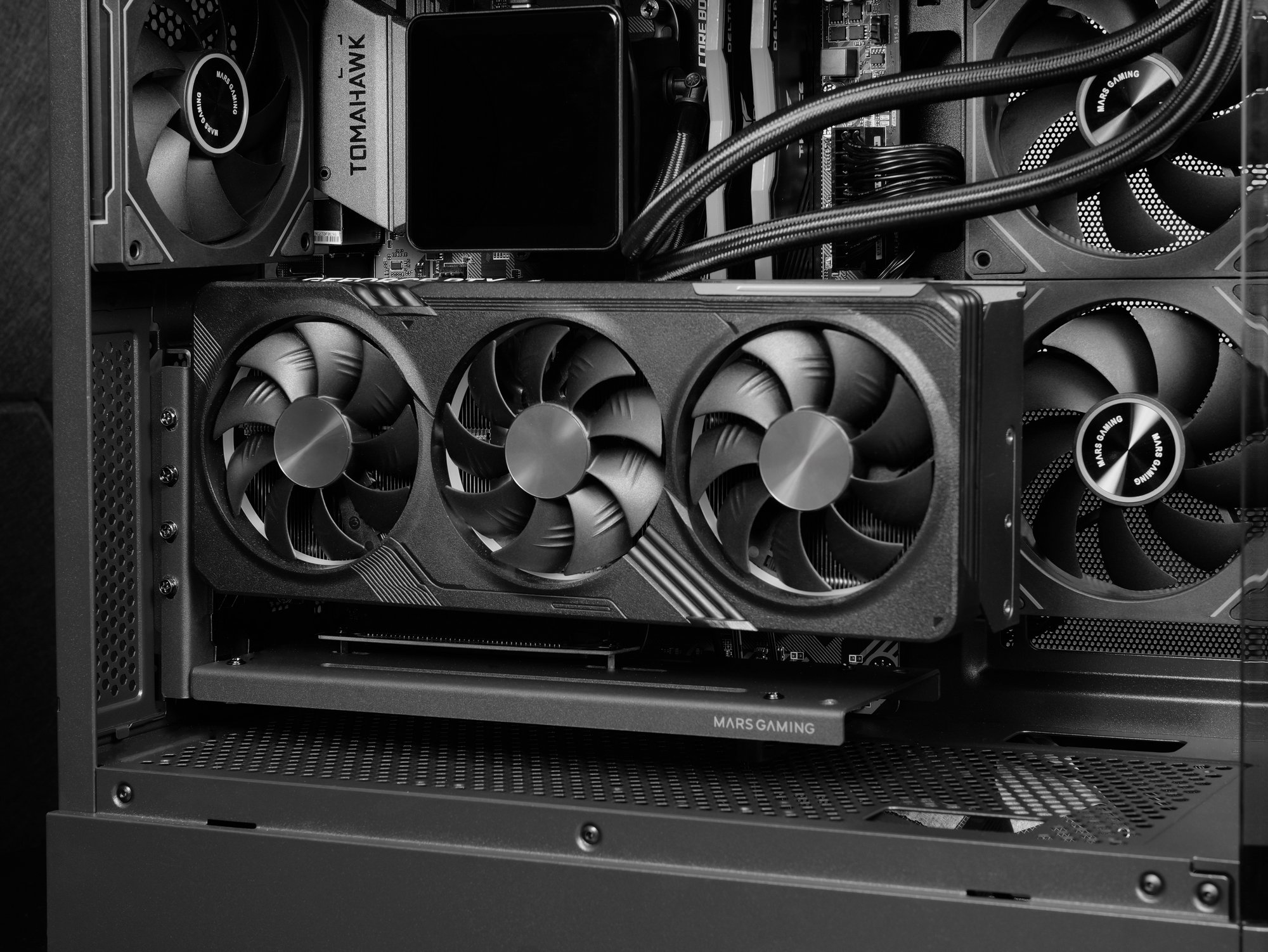 Primo piano dell'interno di un PC da gioco. Una scheda grafica con tre ventole è al centro. Sono visibili ventole e altri componenti.