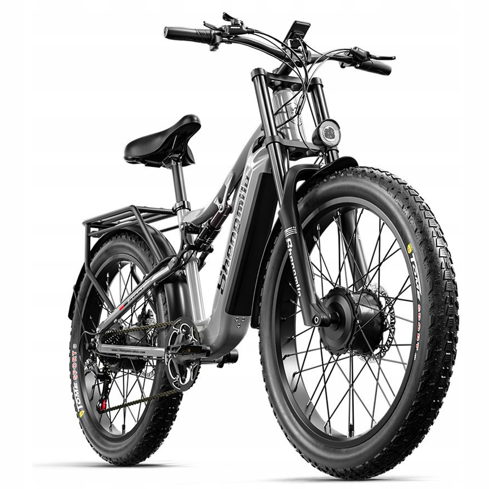 Una bicicleta eléctrica moderna con neumáticos gruesos, cuadro negro y suspensión delantera. Tiene asiento, manillar y portaequipajes.