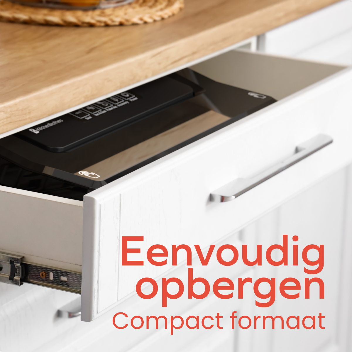 A white drawer is open, revealing a black appliance. The drawer is part of a white cabinet with a wooden countertop.