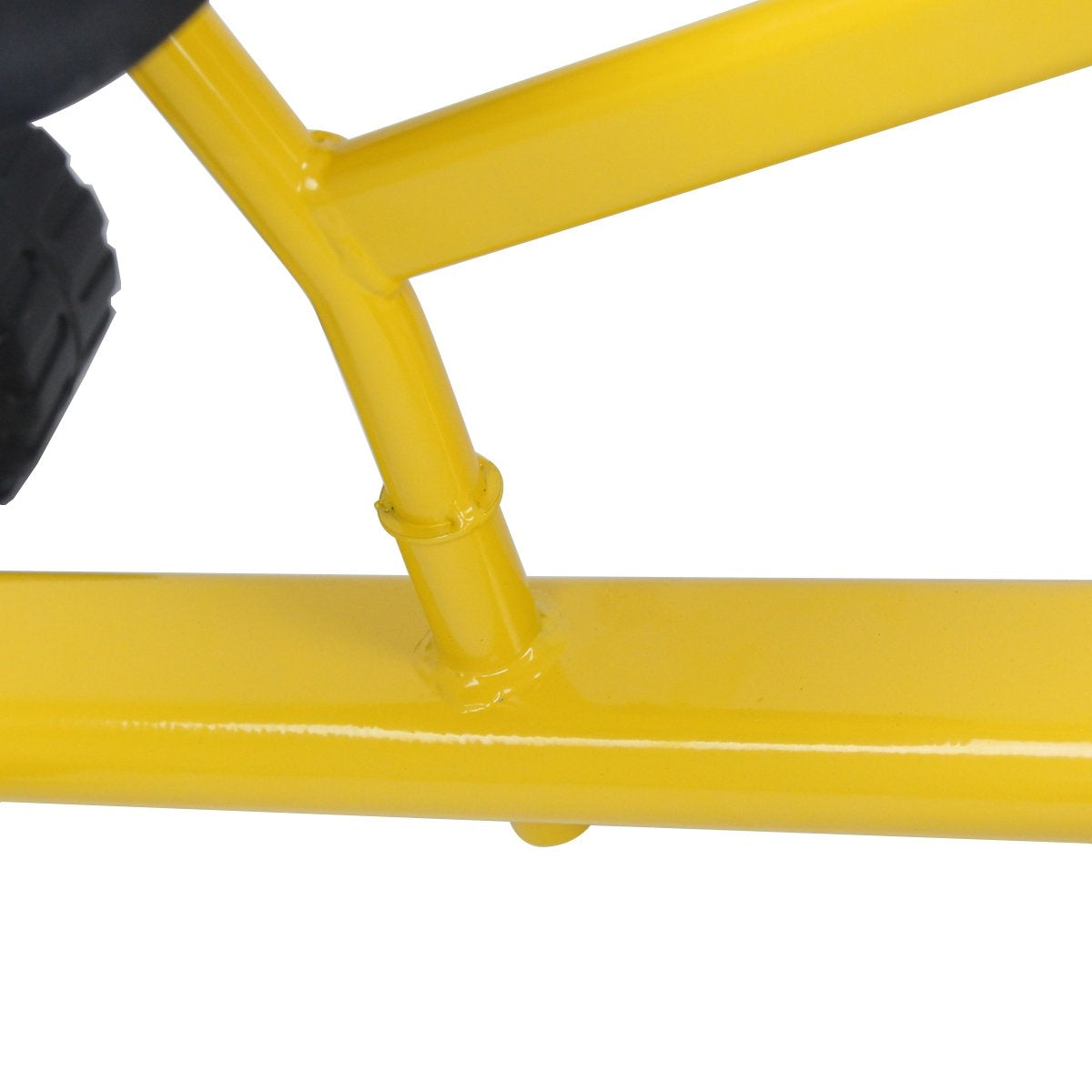 Primer plano de un marco de metal amarillo con juntas soldadas. Un objeto negro está a la izquierda. Fondo blanco.