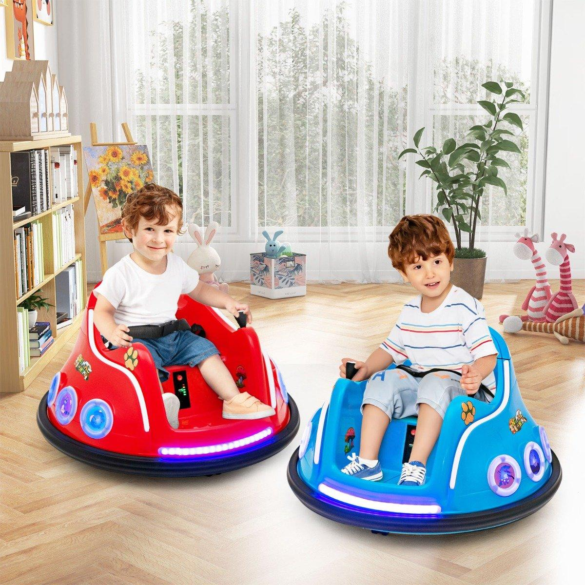 Dos niños pequeños en coches de choque en interiores. Uno rojo, uno azul. Los niños sonríen. Juguetes y plantas en el fondo.