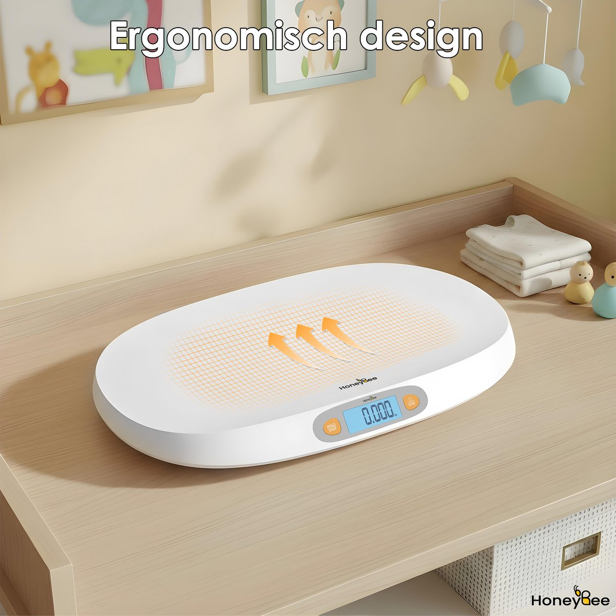 Eine weiße Babywaage mit orangefarbenem Gitter liegt auf einer Holzoberfläche. Ein Digitaldisplay zeigt 0,000. Ein Mobile und gerahmte Bilder sind im Hintergrund.