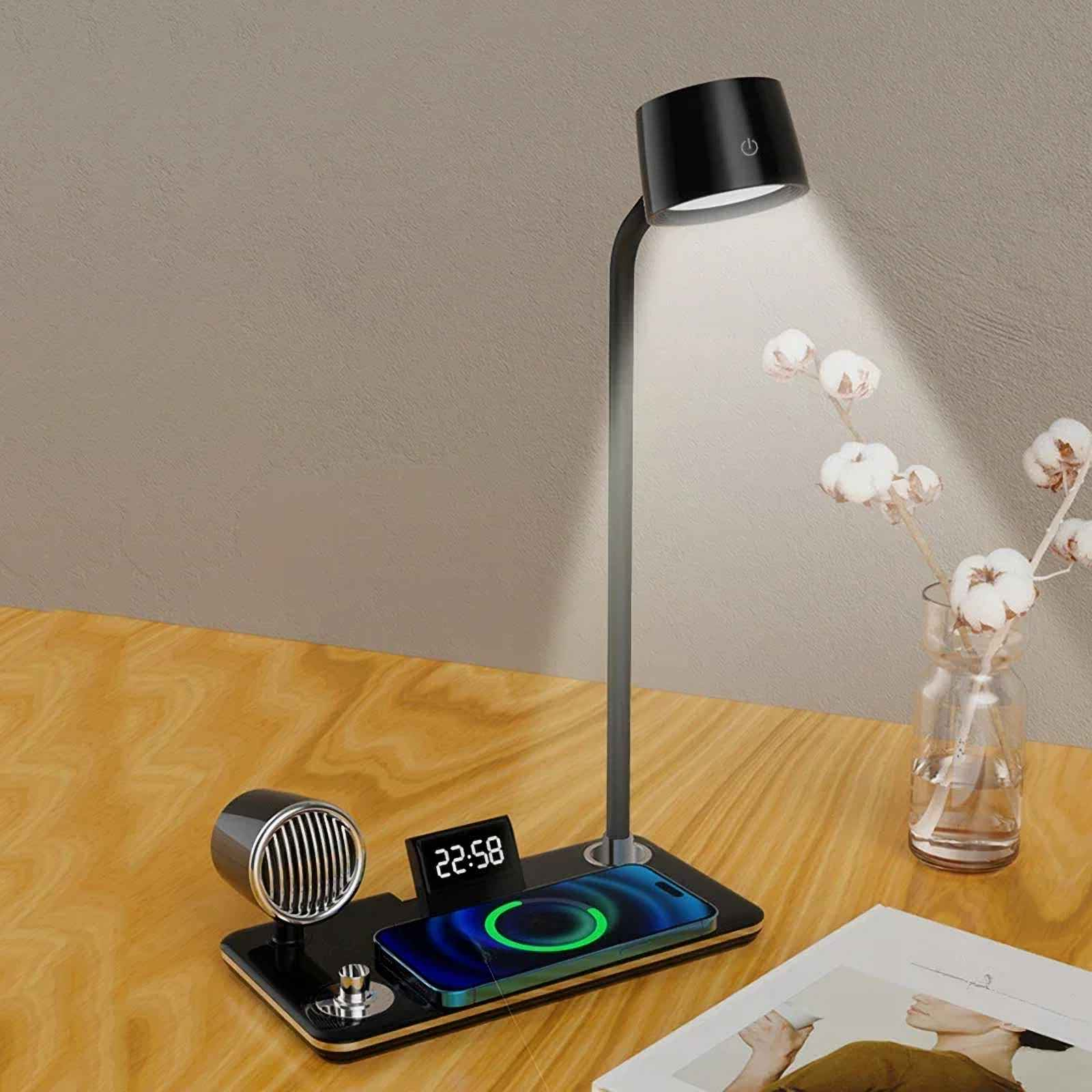 Eine Schreibtischlampe mit Ladepad, Digitaluhr und Lautsprecher. Ein Telefon wird auf dem Pad geladen. Eine Vase mit Blumen steht rechts.