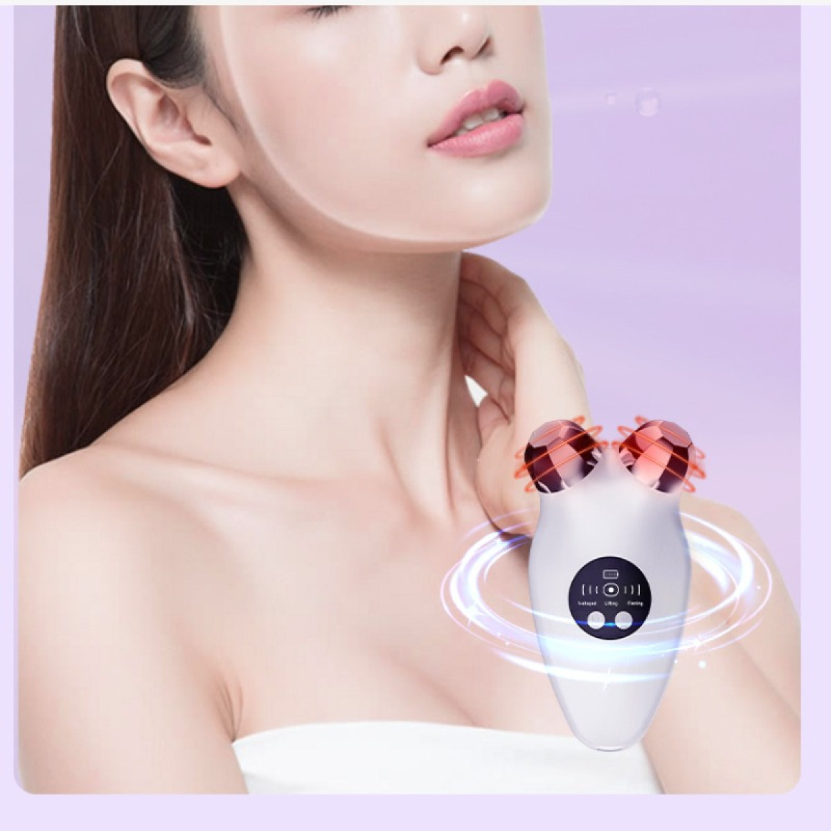 Kobieta trzyma masażer do twarzy. Masażer jest biały z dwoma czerwonymi, fasetowanymi rolkami. Kobieta ma jasną skórę i długie, ciemne włosy.