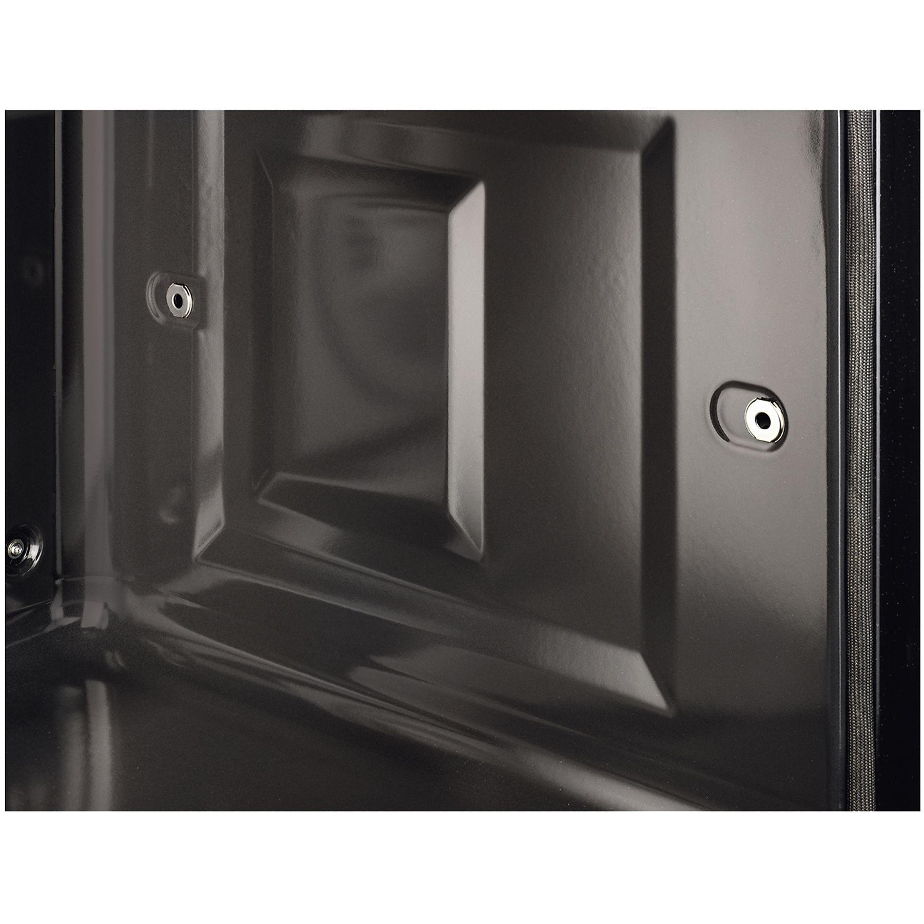 Primo piano di una porta del forno grigio scuro. Ha un pannello rettangolare incassato, ferramenta e un bordo strutturato.