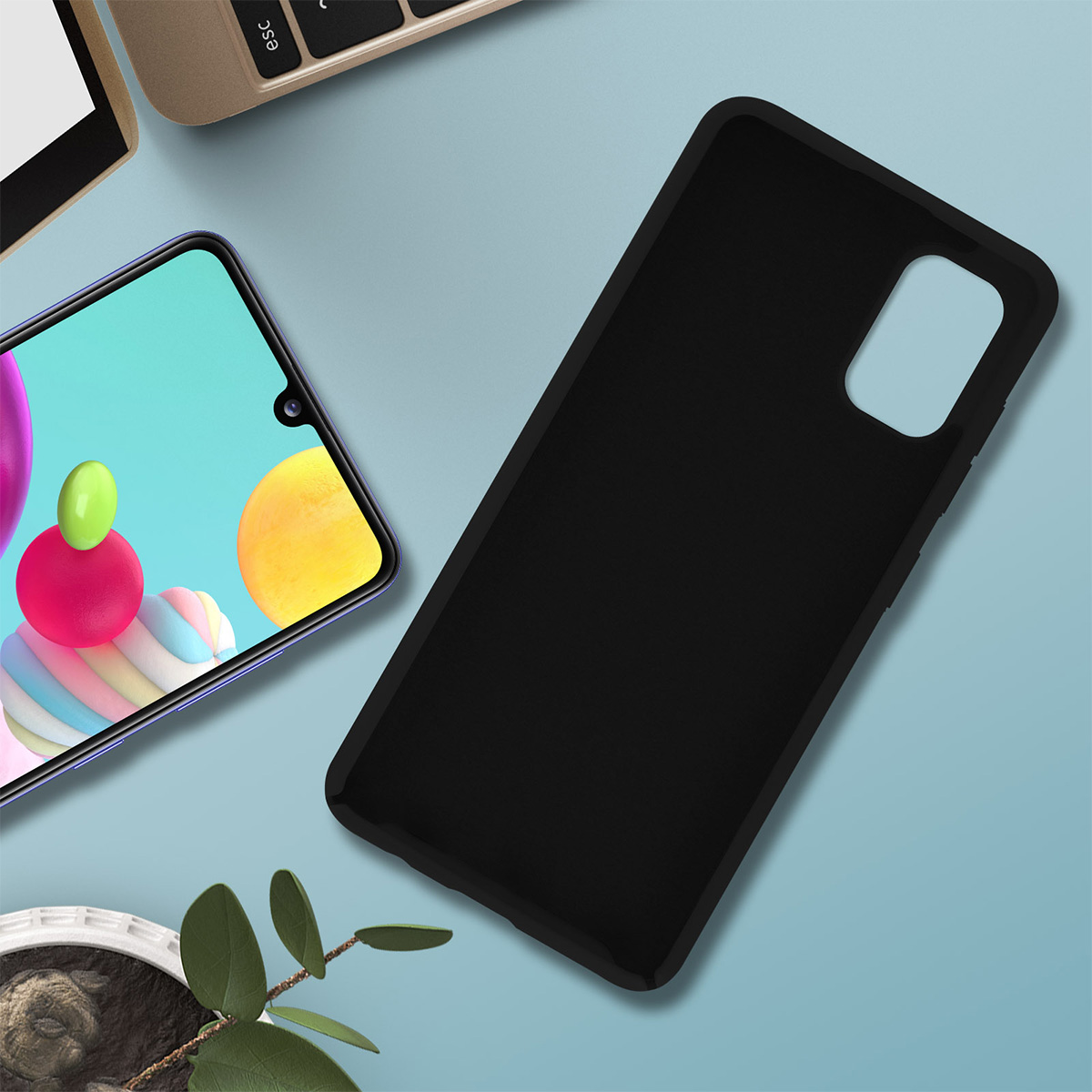 Een telefoonhoesje en een telefoon liggen op een blauw oppervlak. Het telefoonscherm toont kleurrijke vormen. Een toetsenbord is zichtbaar.