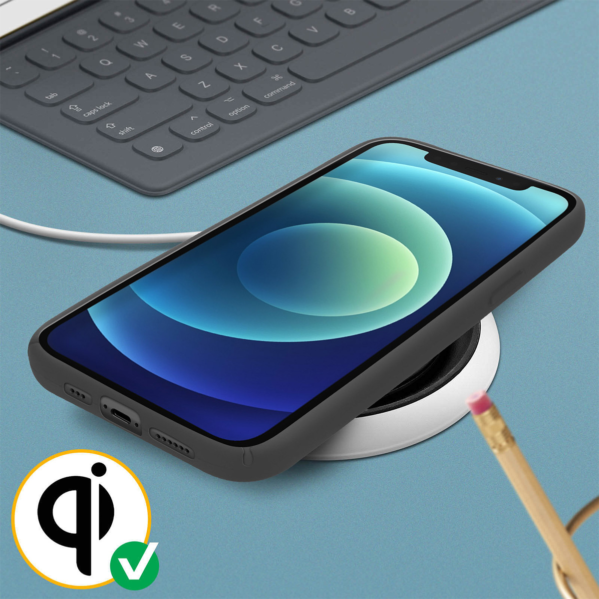 Un telefono su un caricabatterie wireless, con una tastiera sullo sfondo. Matita vicina. Un logo Qi con un segno di spunta è visibile.