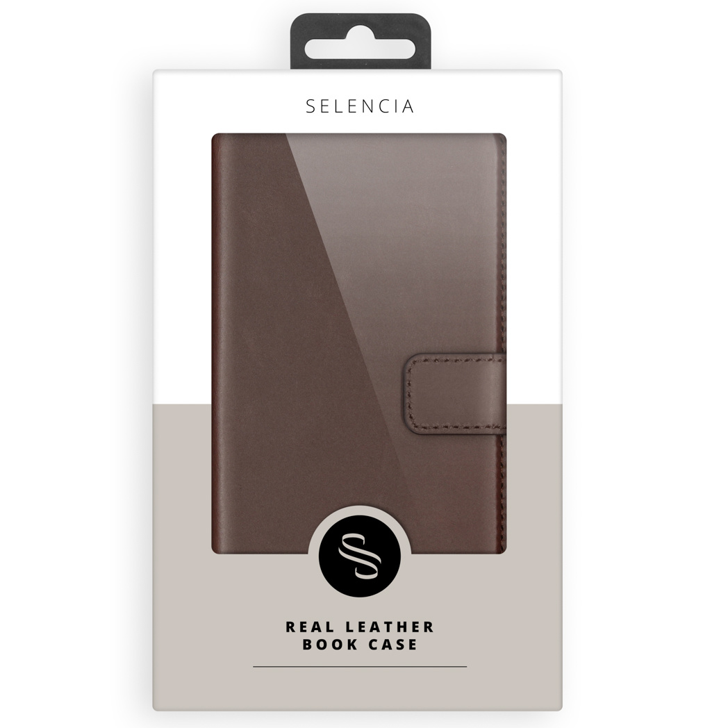 Un étui de livre en cuir marron dans un emballage. L'emballage est blanc avec une fenêtre transparente. La marque Selencia est en haut.