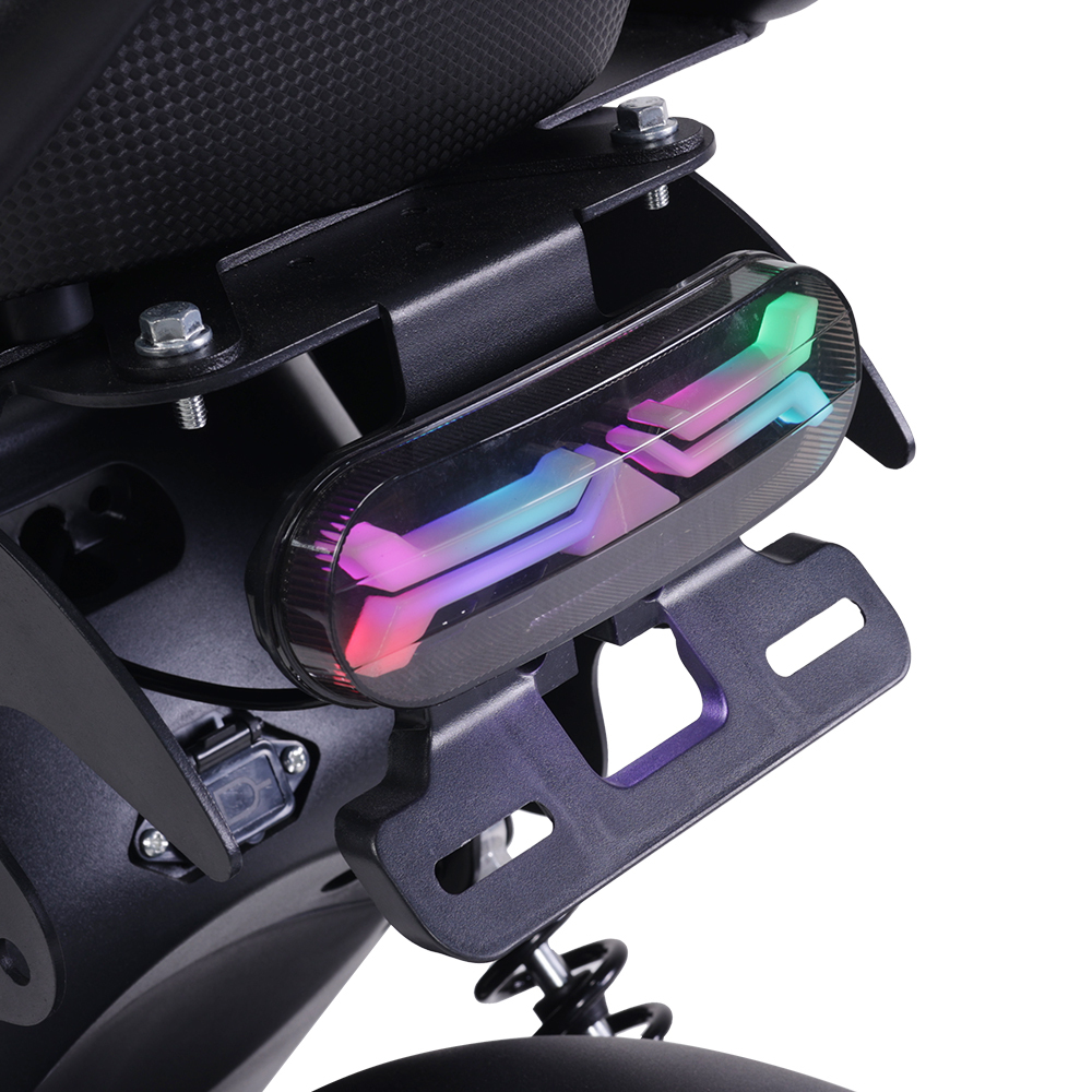 Zbliżenie tylnego światła motocykla, z kolorową matrycą LED. Światło zamontowane na czarnej ramie. Tło jest białe.