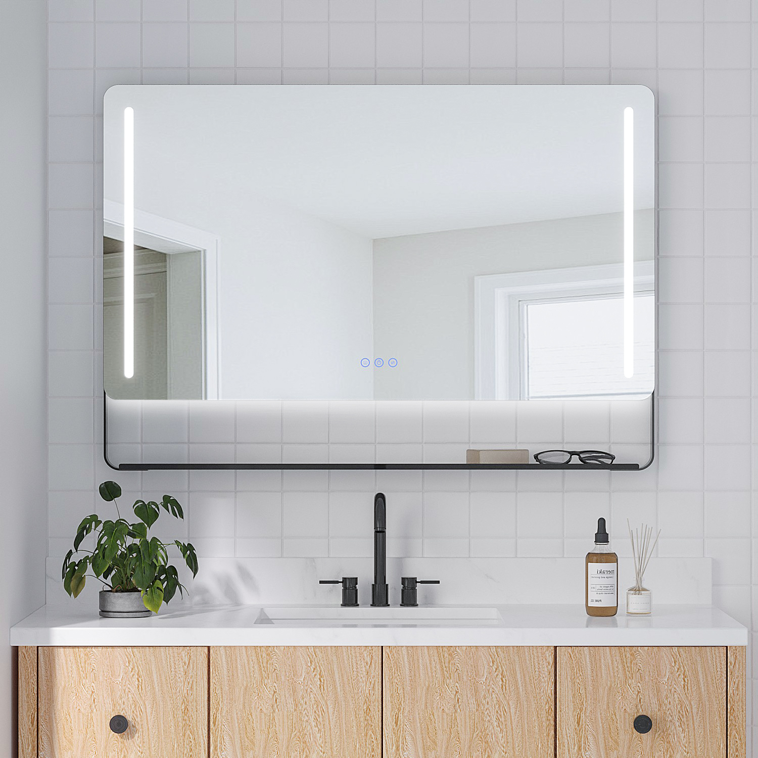 Badezimmer mit beleuchtetem Spiegel, Waschbecken und Holzschrank. Eine Pflanze, Brille und Diffusor stehen auf der Theke.
