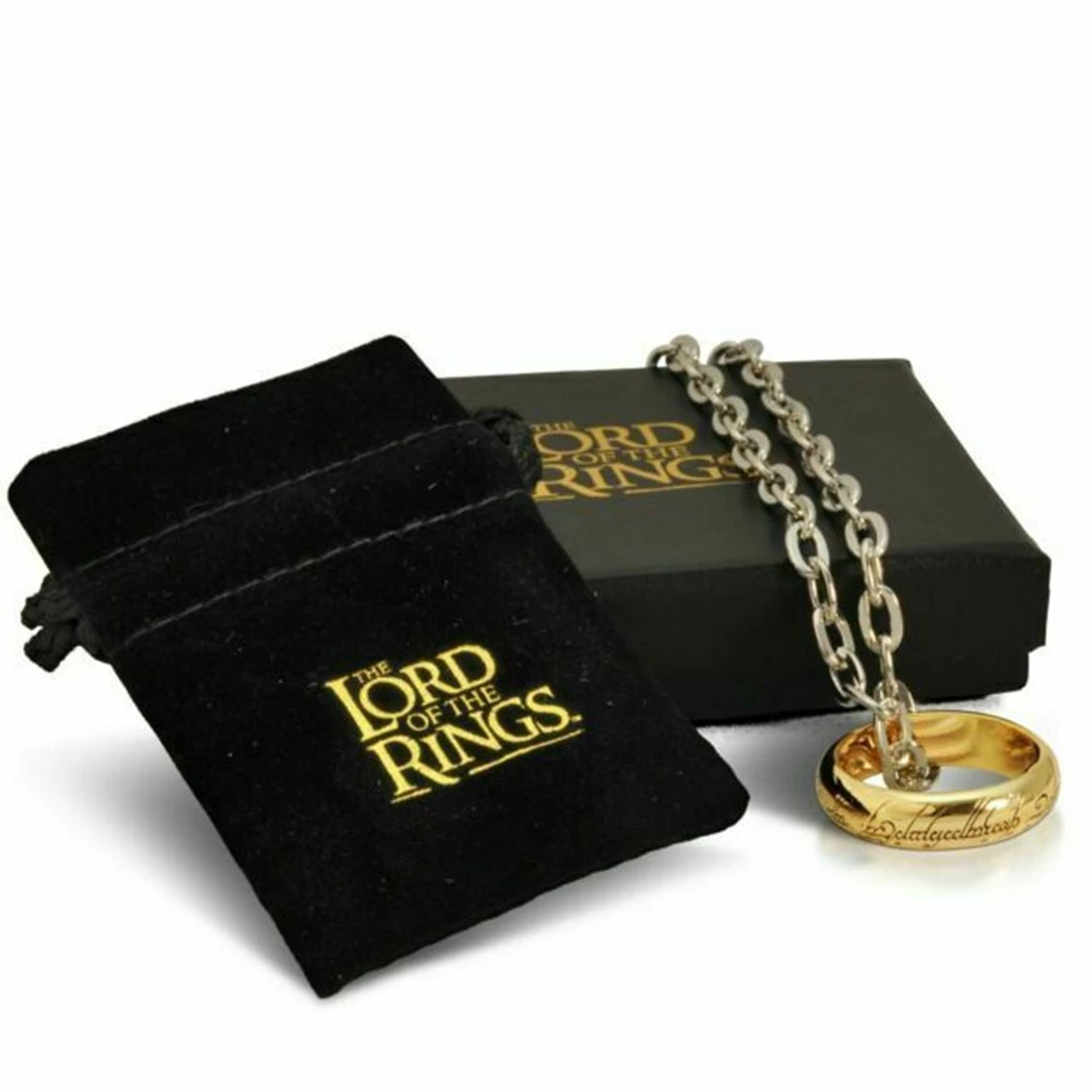 Un anillo dorado con inscripción cuelga de una cadena plateada. También hay una bolsa de terciopelo negro y una caja con "El Señor de los Anillos".