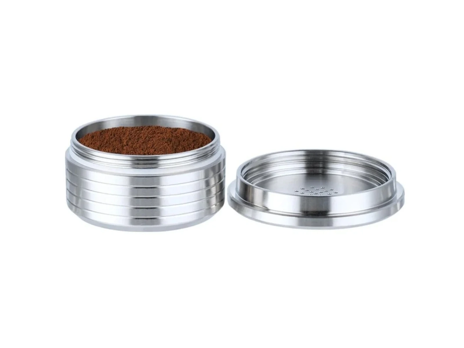 Ein metallischer Kaffeebereiter mit Kaffeepulver im Inneren und seinem Deckel daneben, vor weißem Hintergrund.